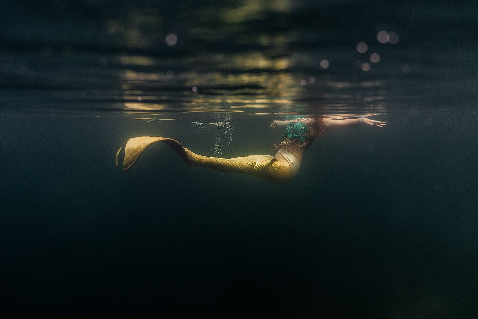 A mermaid is swimming underwater in the ocean.