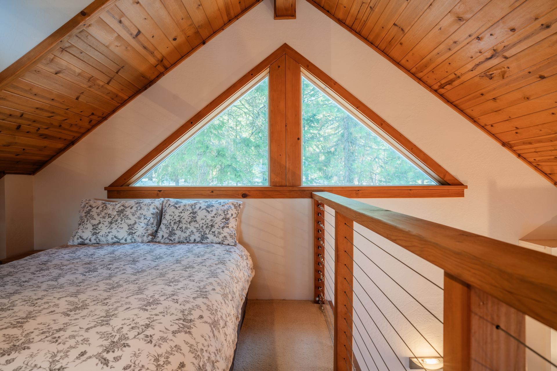 A bedroom with a triangle window and a bed