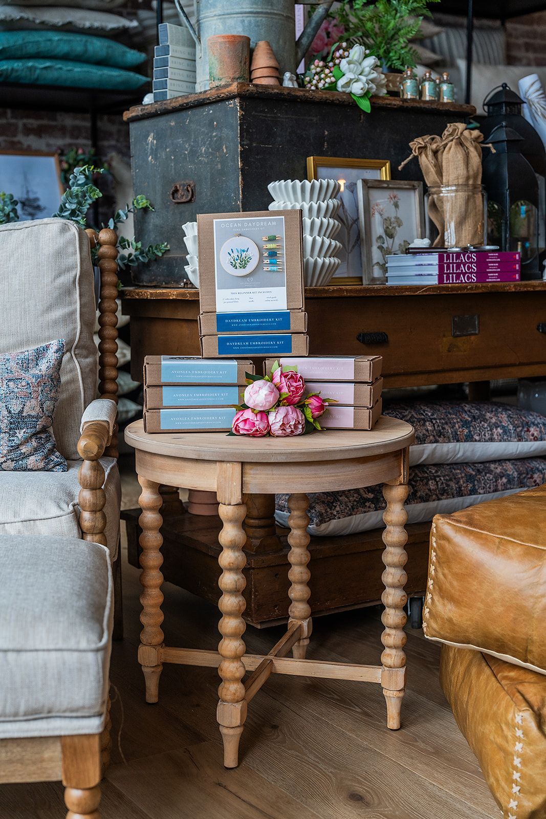 A wooden table with books and flowers on it in a living room.