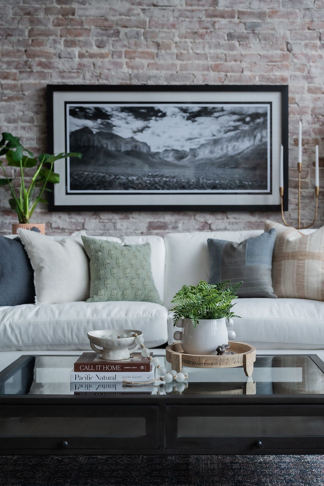 A living room with a couch , coffee table , and a picture on the wall.