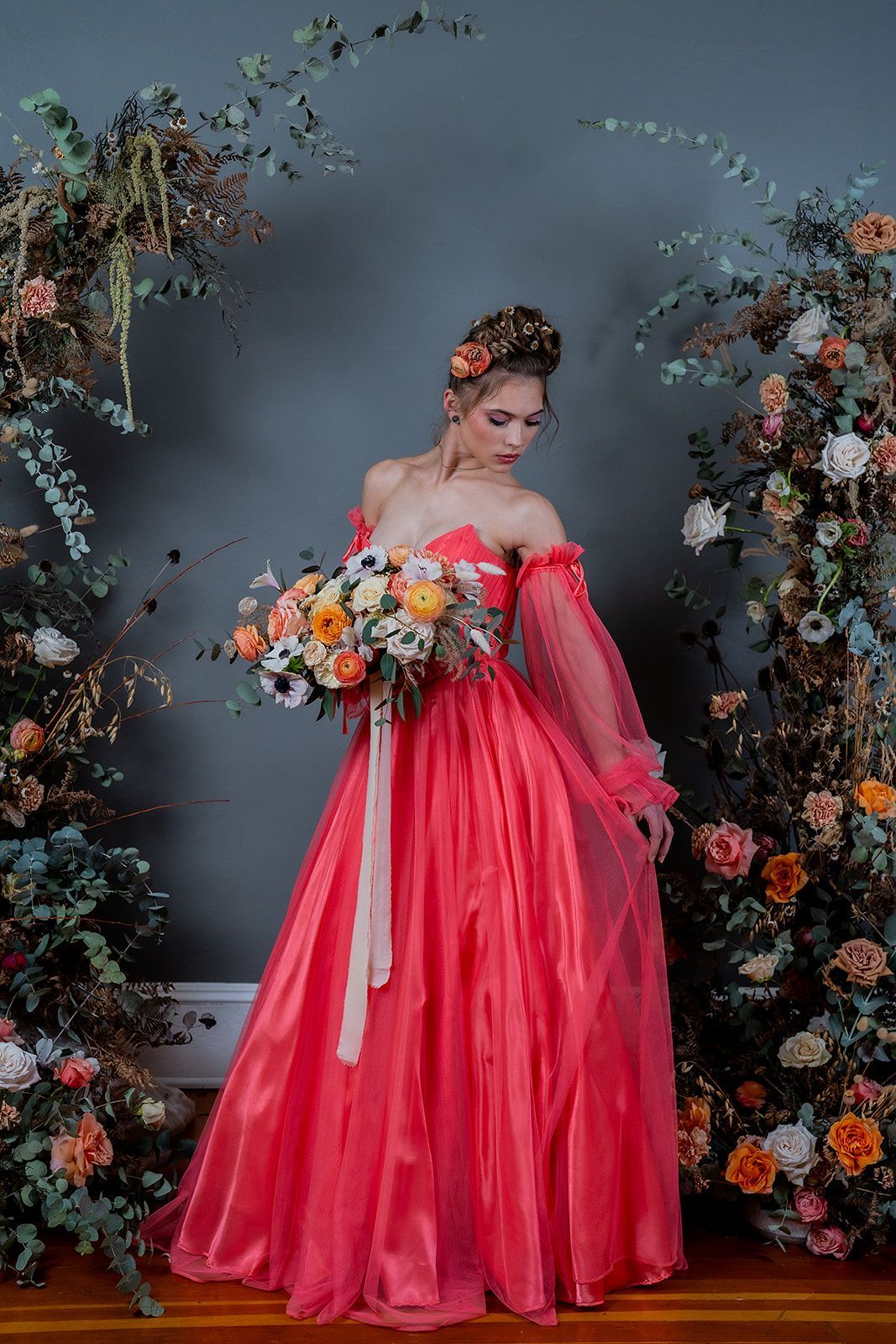 A woman in a red dress is holding a bouquet of flowers.