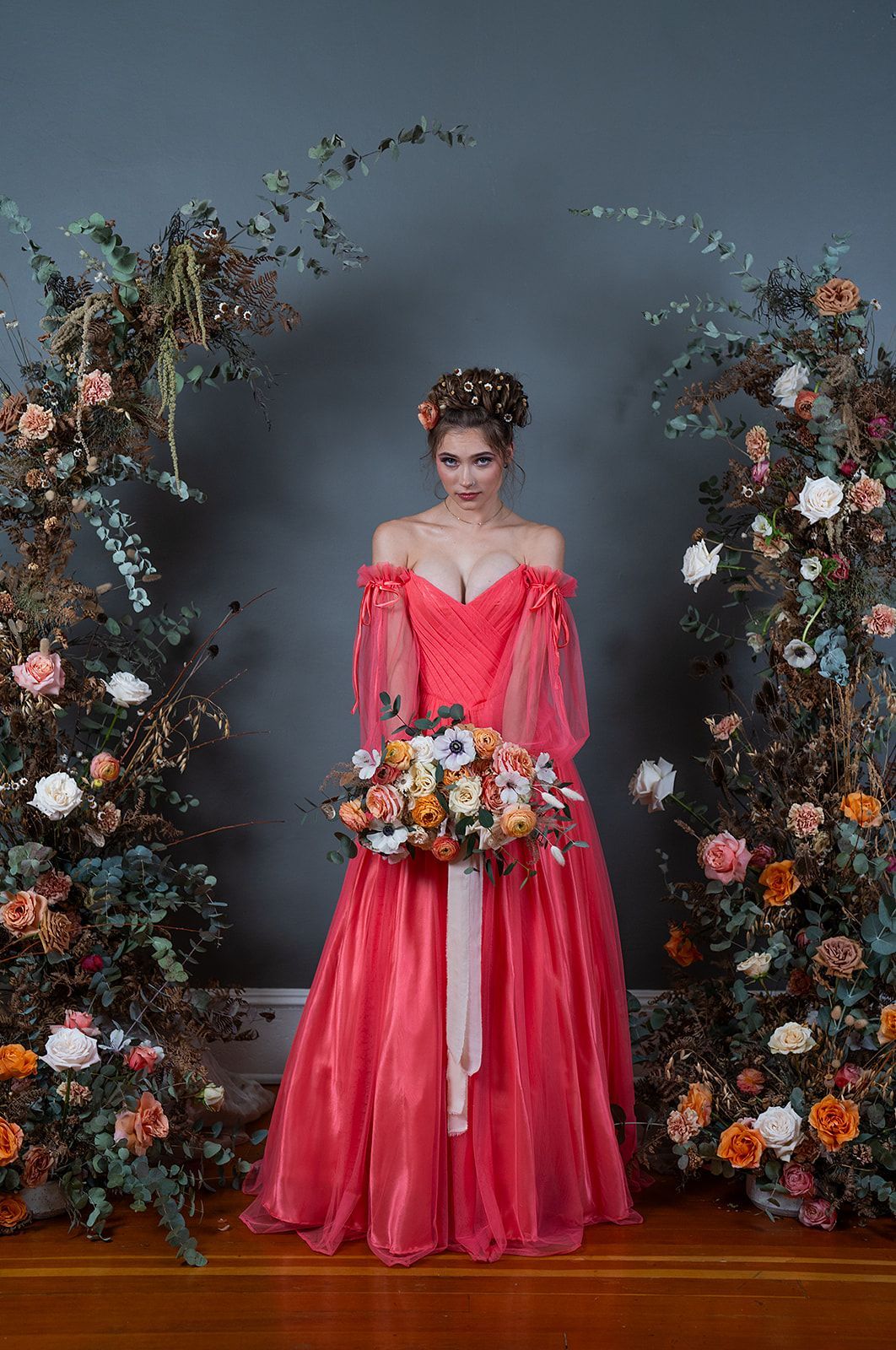 A woman in a red dress is holding a bouquet of flowers.