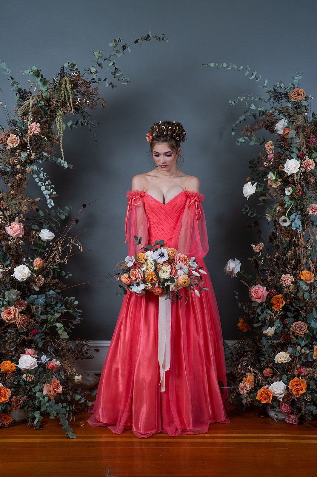 A woman in a red dress is holding a bouquet of flowers.