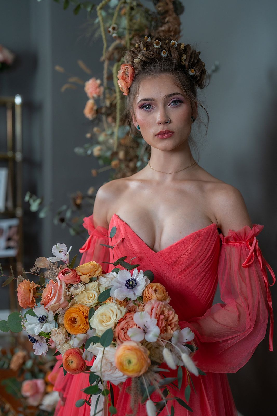 A woman in a red dress is holding a bouquet of flowers.
