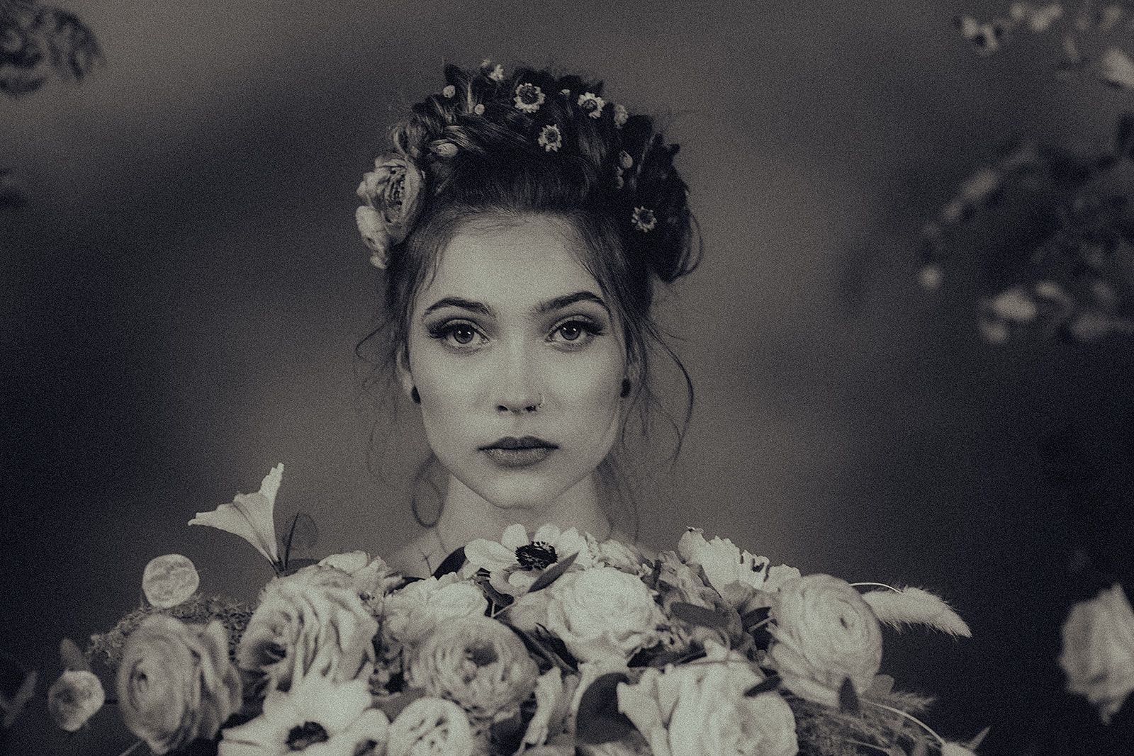 A woman is holding a bouquet of flowers in a black and white photo.