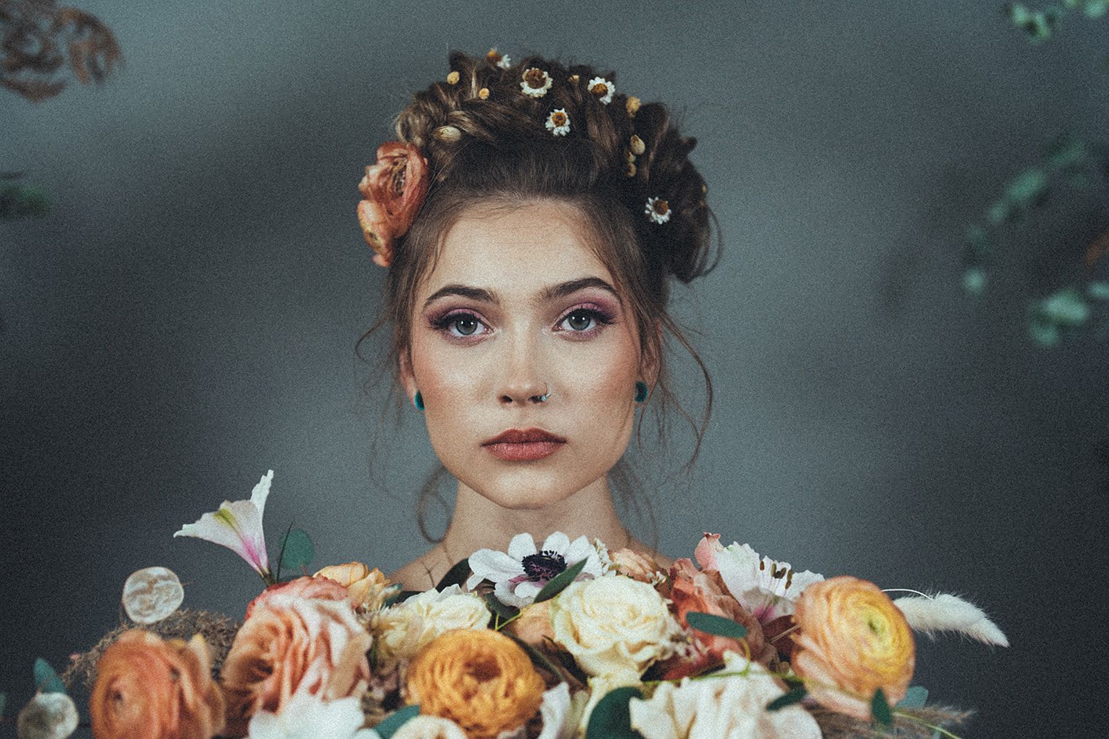 A woman with flowers in her hair is holding a bouquet of flowers.