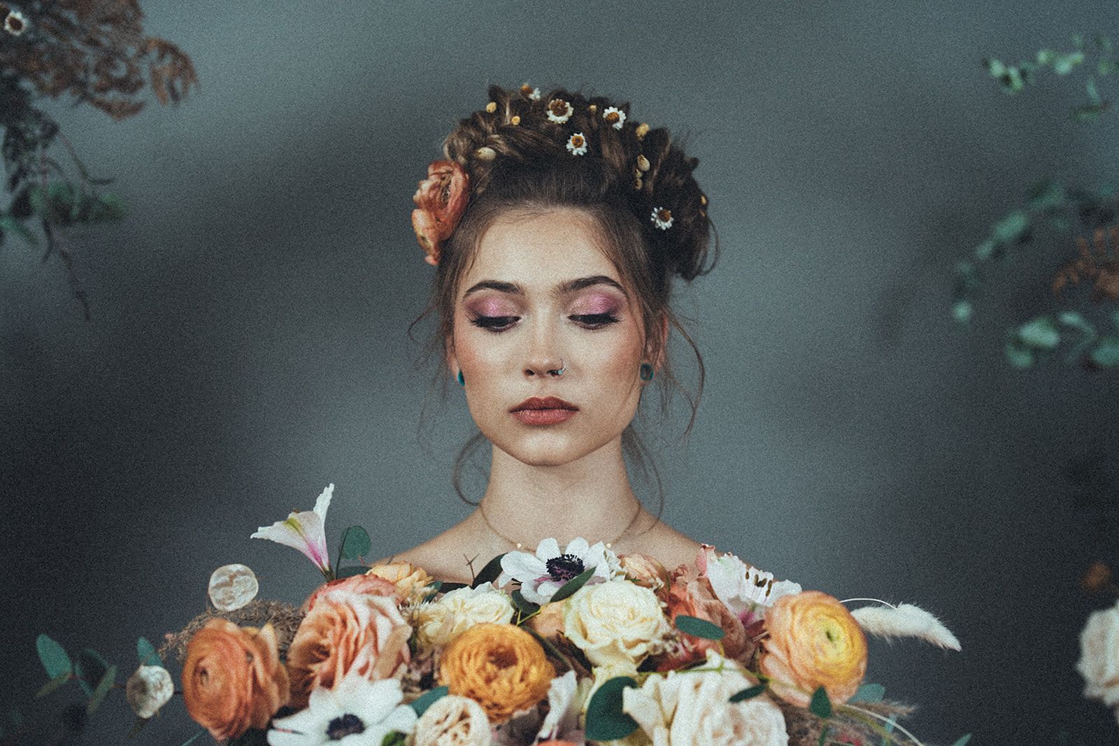 A woman with a flower crown on her head is holding a bouquet of flowers.