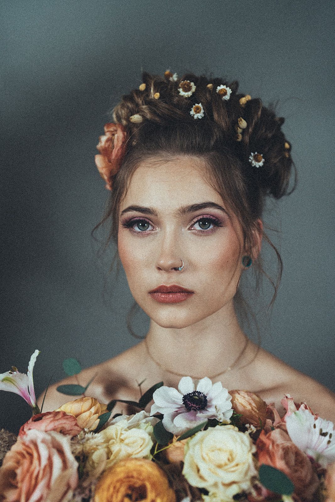 A woman with flowers in her hair is holding a bouquet of flowers.
