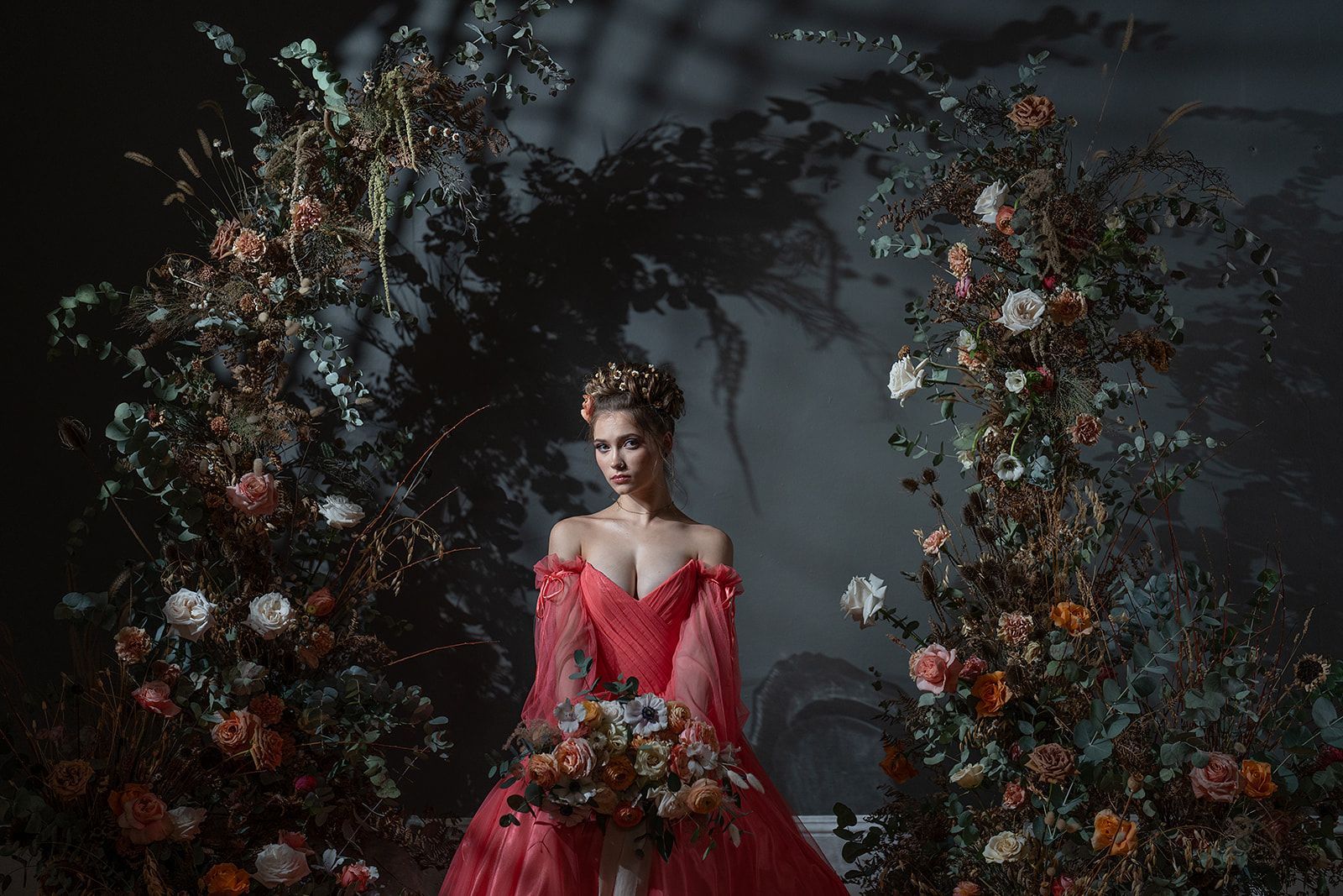 The woman is wearing a red dress and holding a bouquet of flowers.