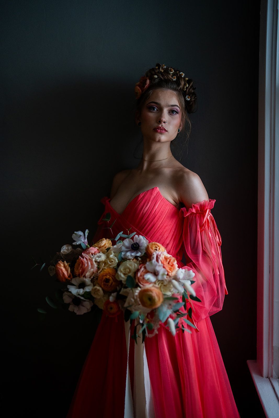 A woman in a red dress is holding a bouquet of flowers.