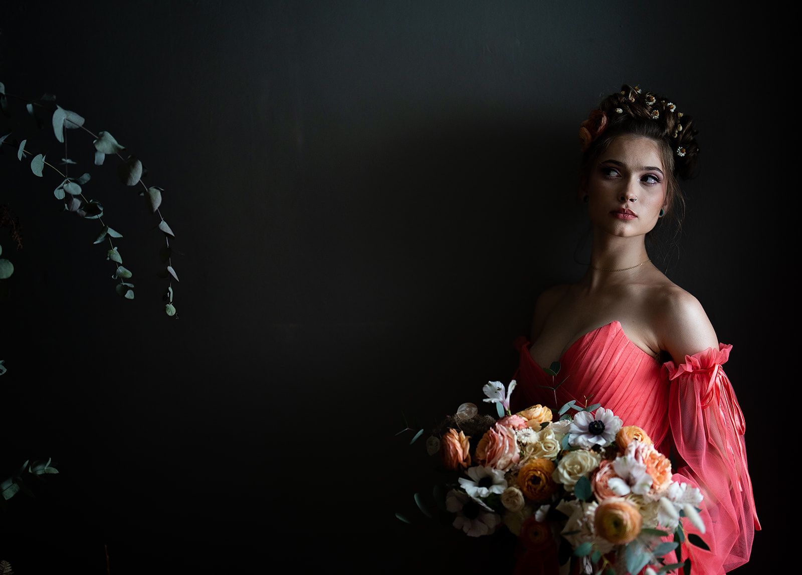 A woman in a red dress is holding a bouquet of flowers.