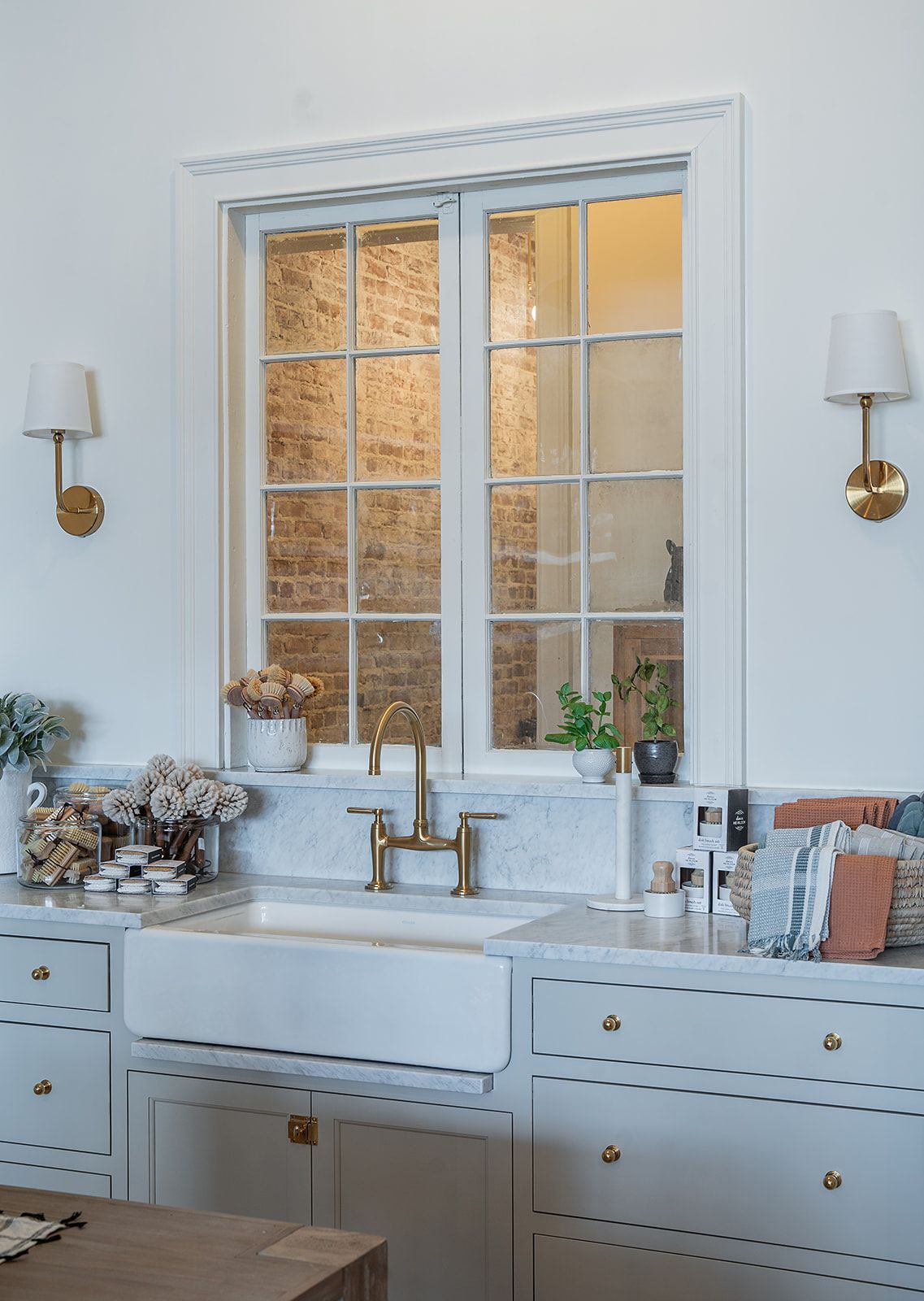 A kitchen with a sink , cabinets , and a window.