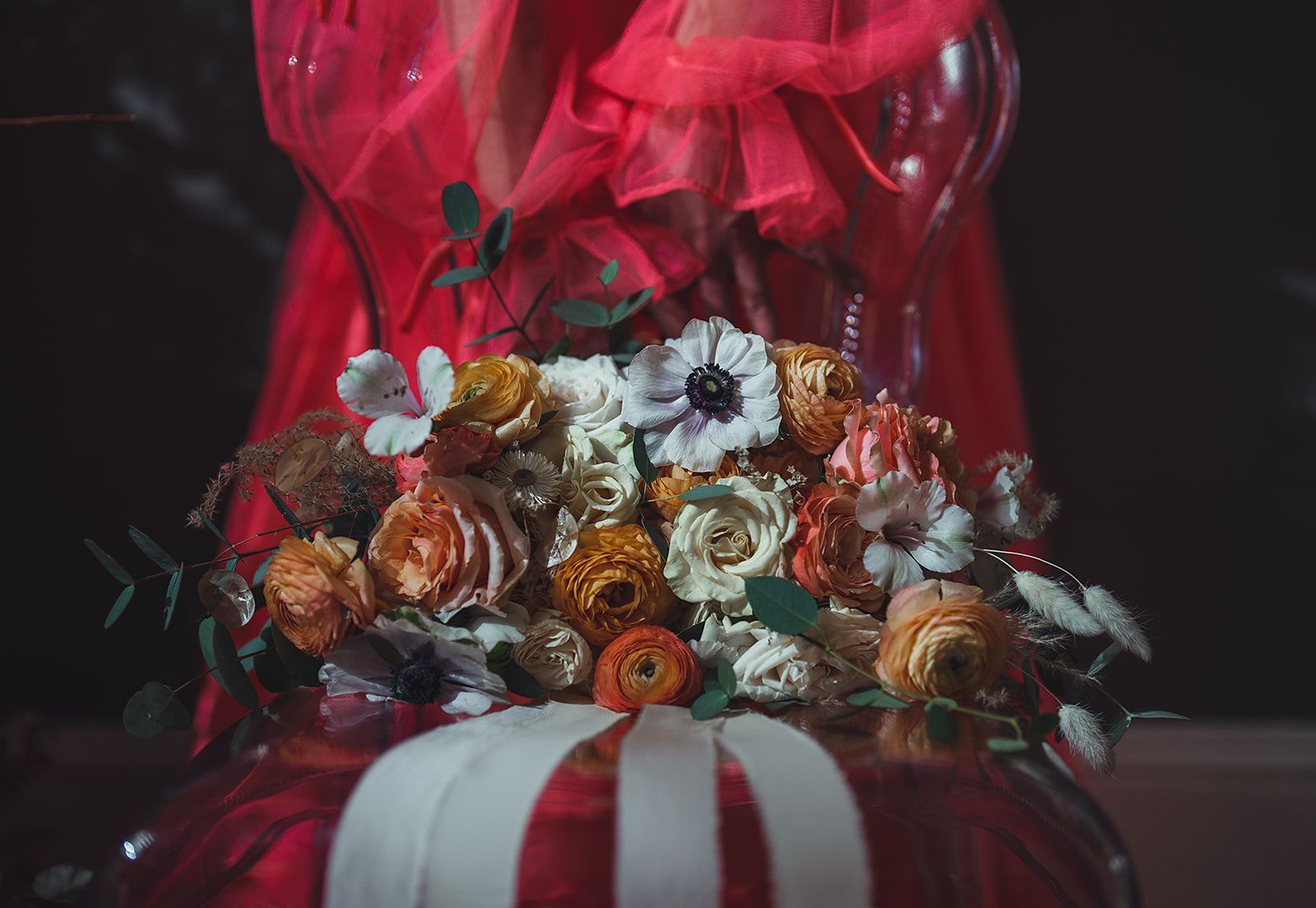 A woman in a red dress is holding a bouquet of flowers.