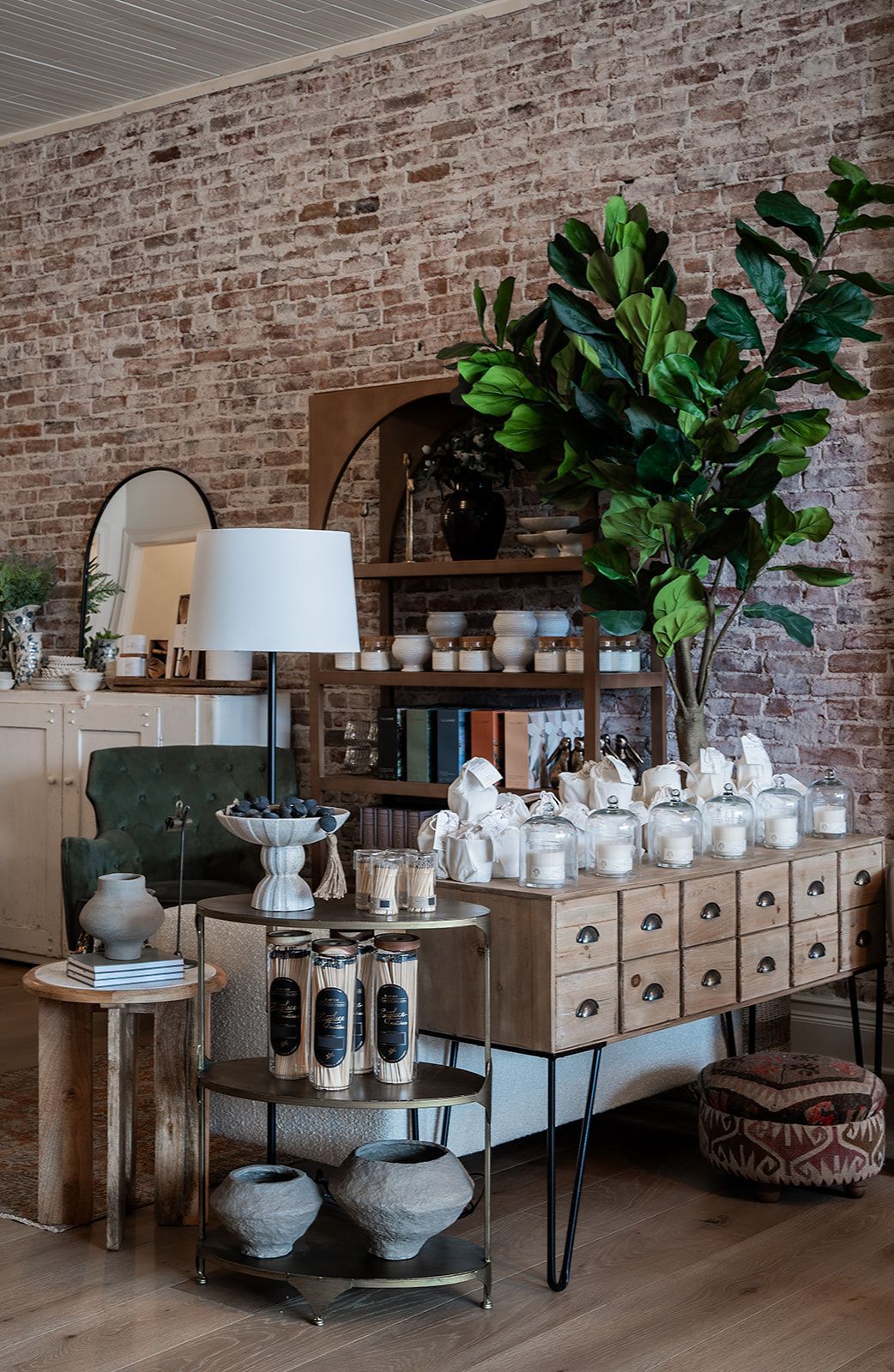 A living room filled with furniture and candles and a brick wall.