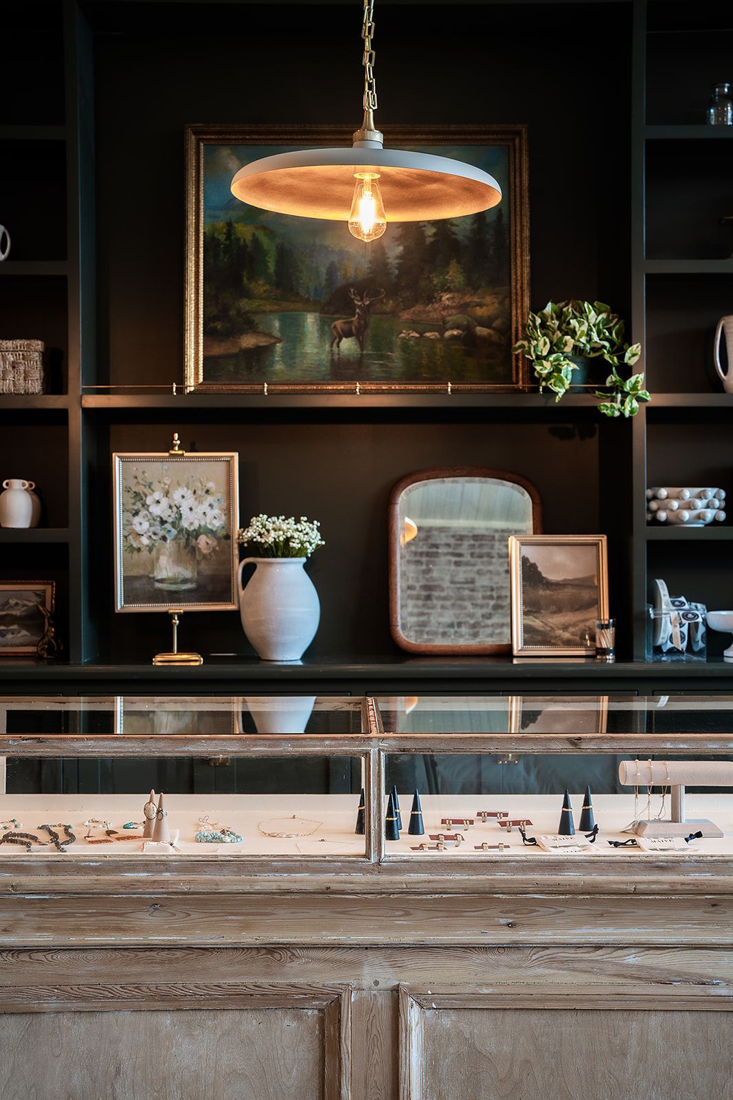 A jewelry store with a display case and a painting on the wall.