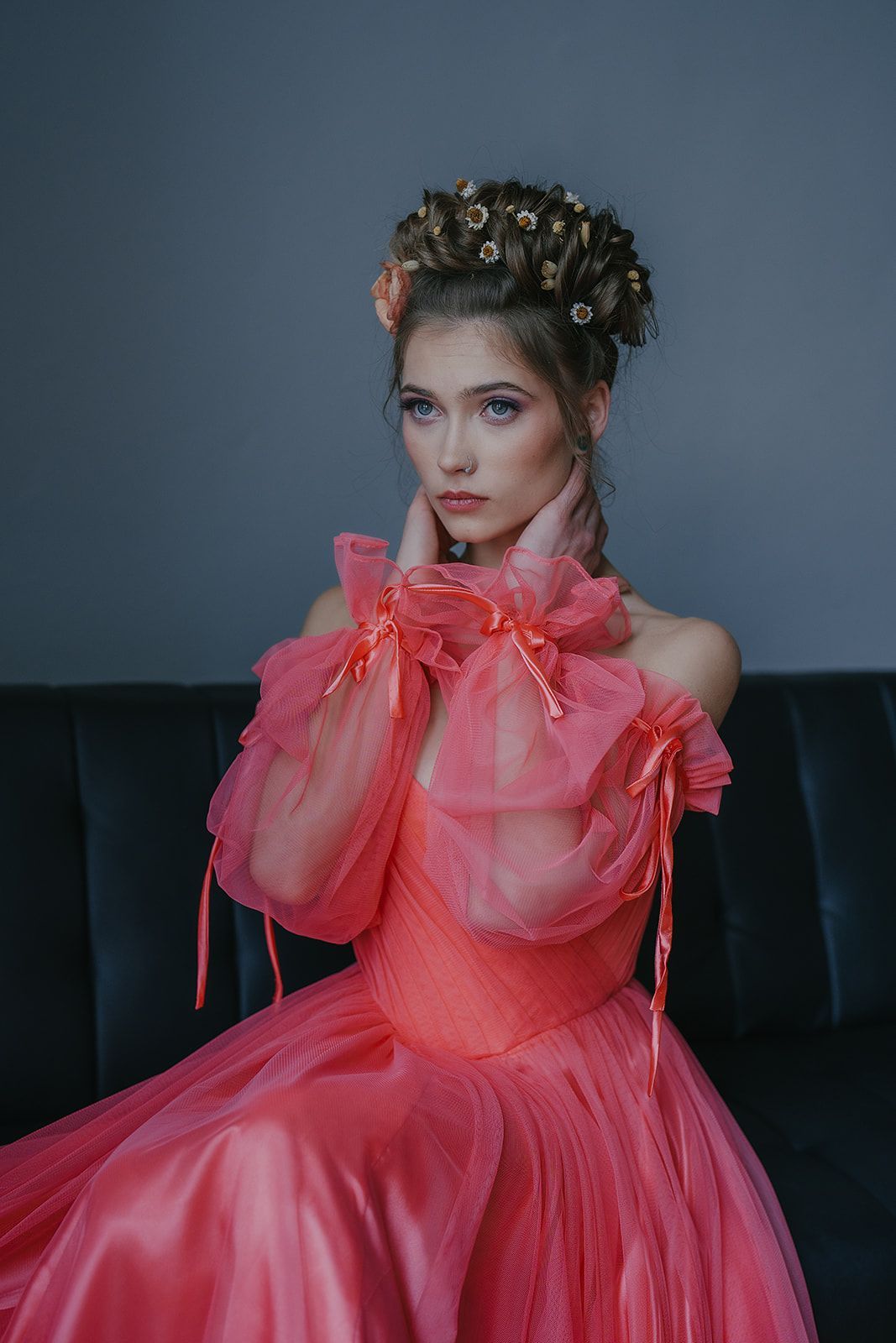 A woman in a pink dress is sitting on a couch.