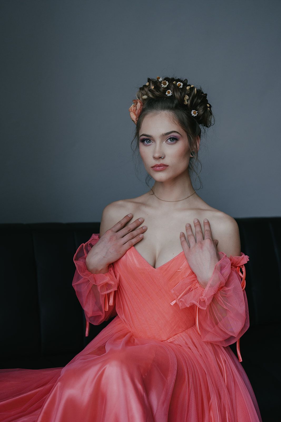 A woman in a pink dress is sitting on a couch.