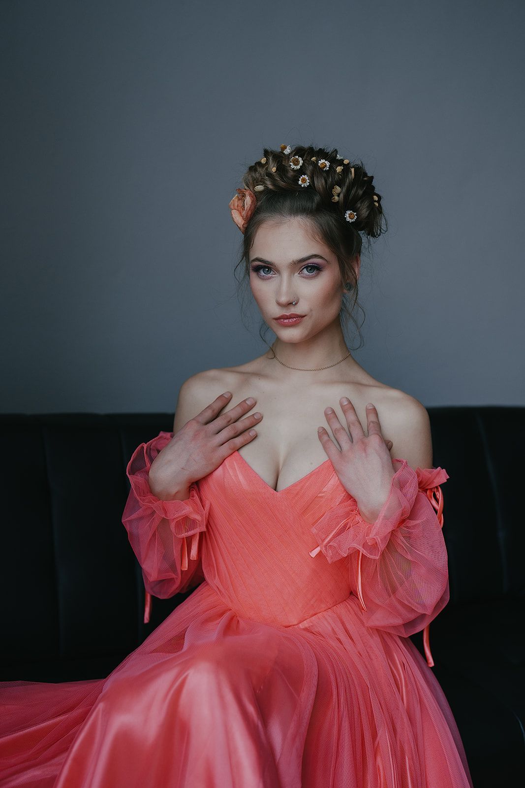 A woman in a pink dress is sitting on a couch.