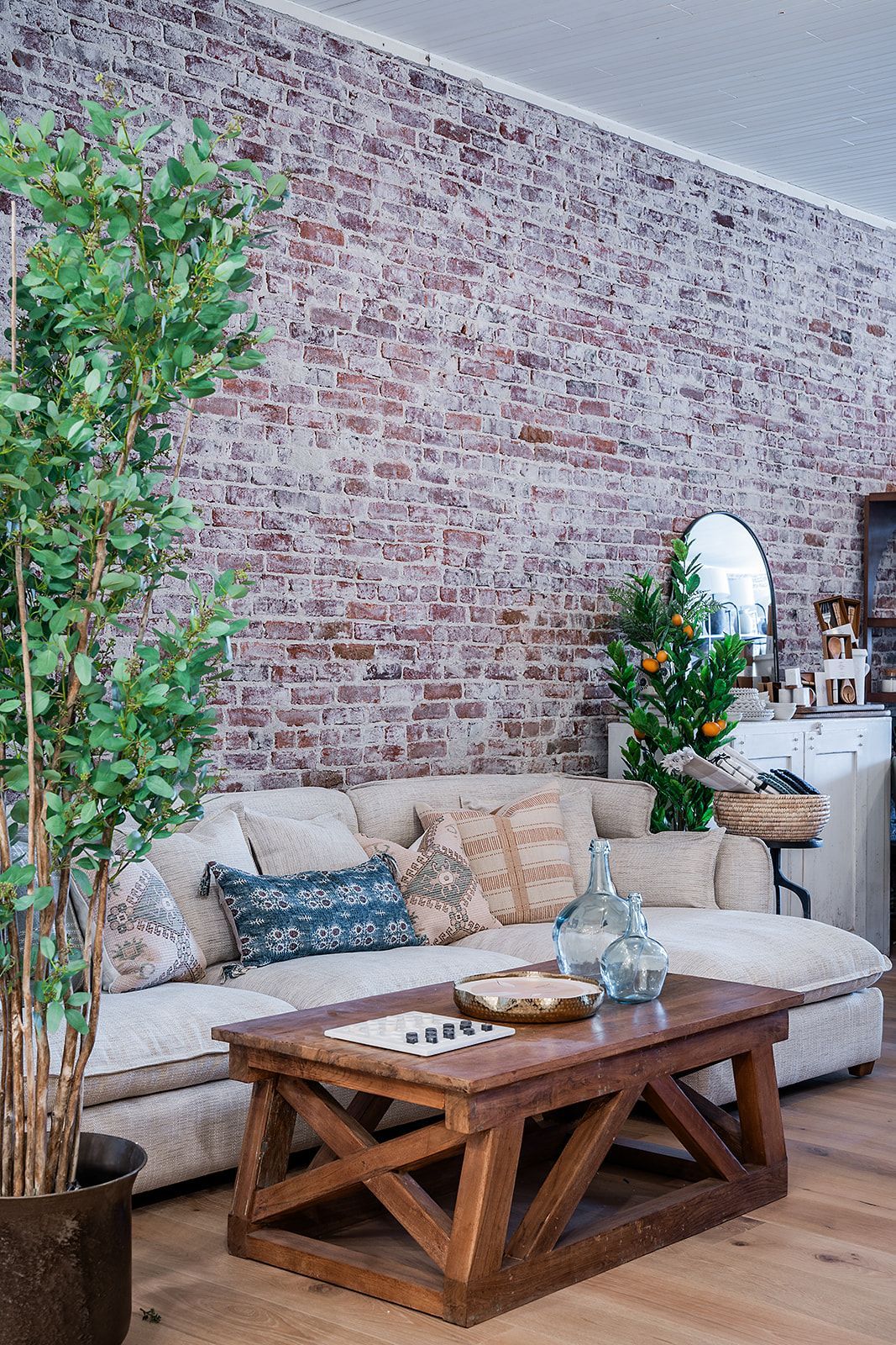 A living room with a couch , coffee table , and brick wall.