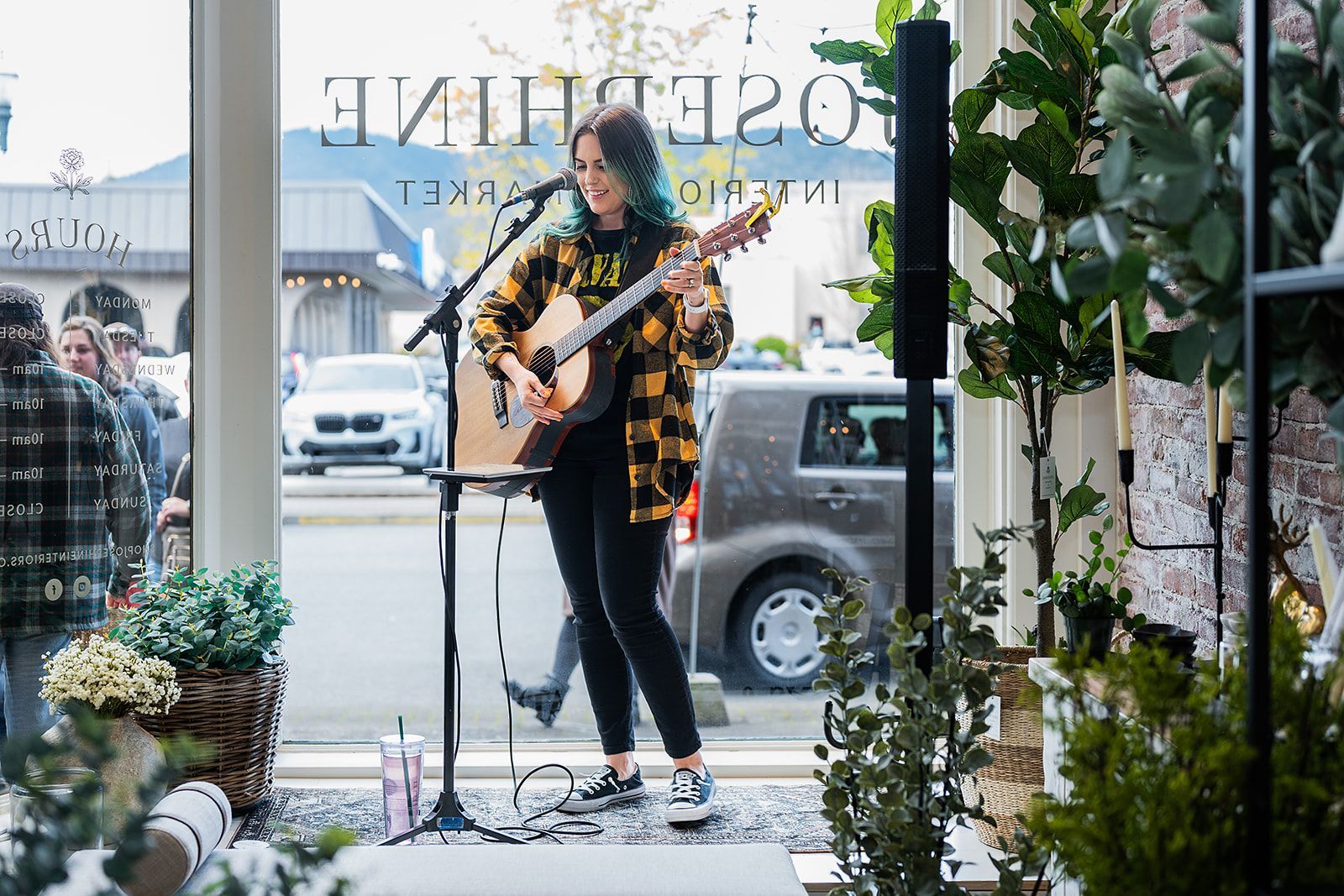 A woman is playing a guitar and singing into a microphone.