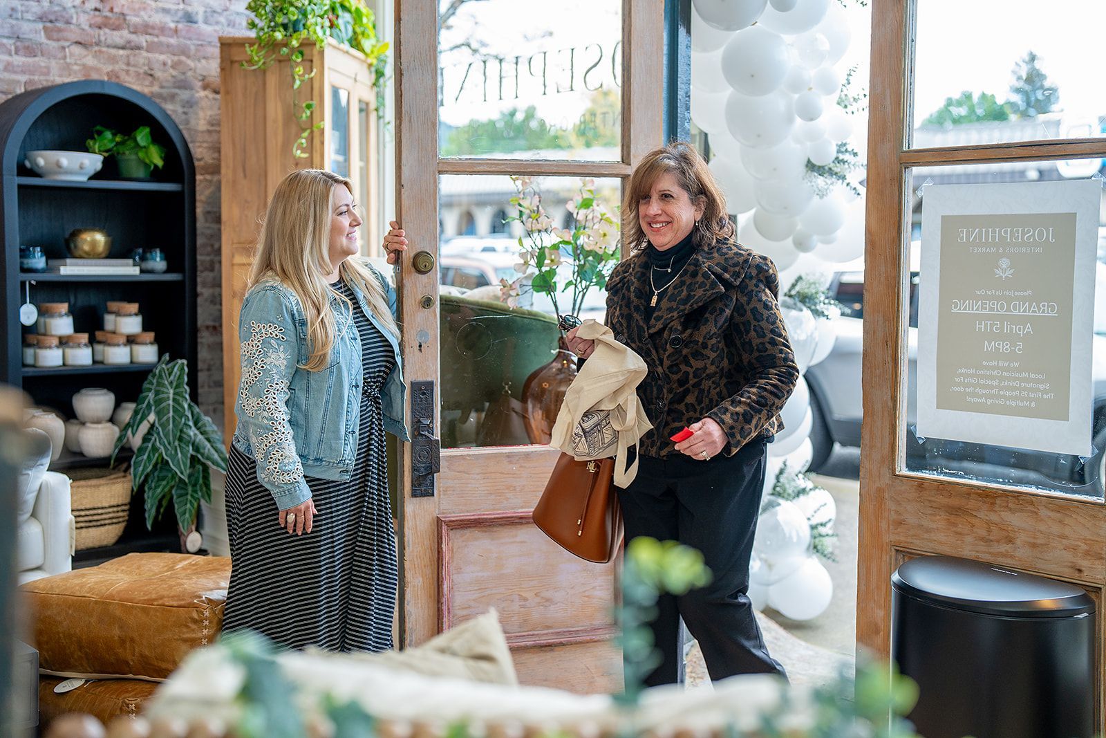 Two women are standing in a store talking to each other.