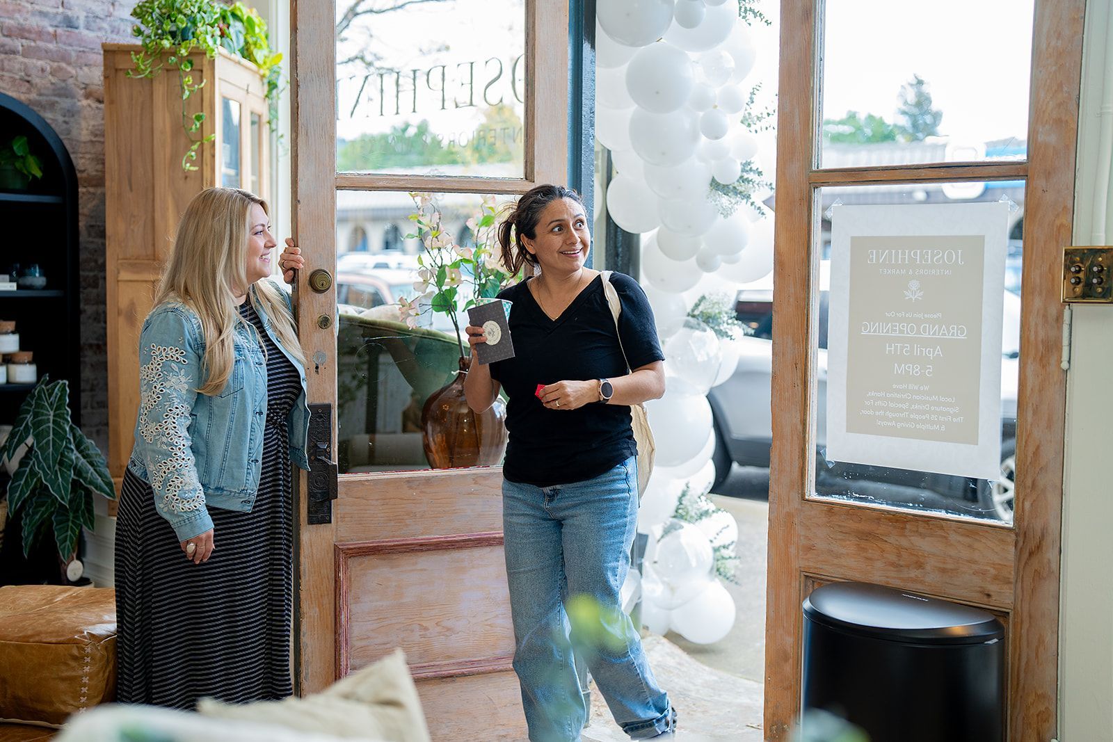 Two women are standing in front of a store door.