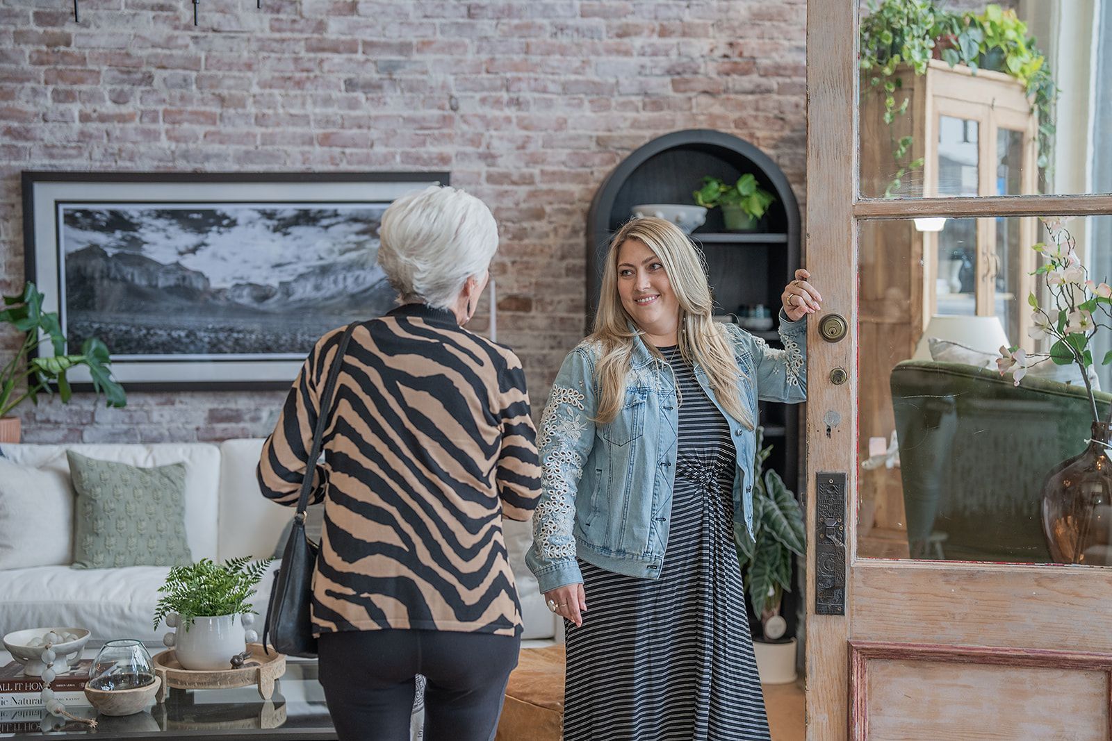 Two women are standing next to each other in a living room.