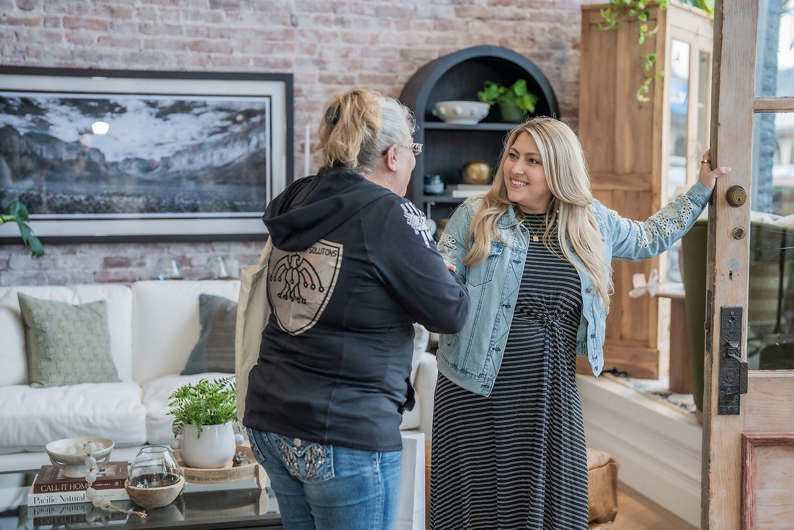 Two women are standing next to each other in a living room.