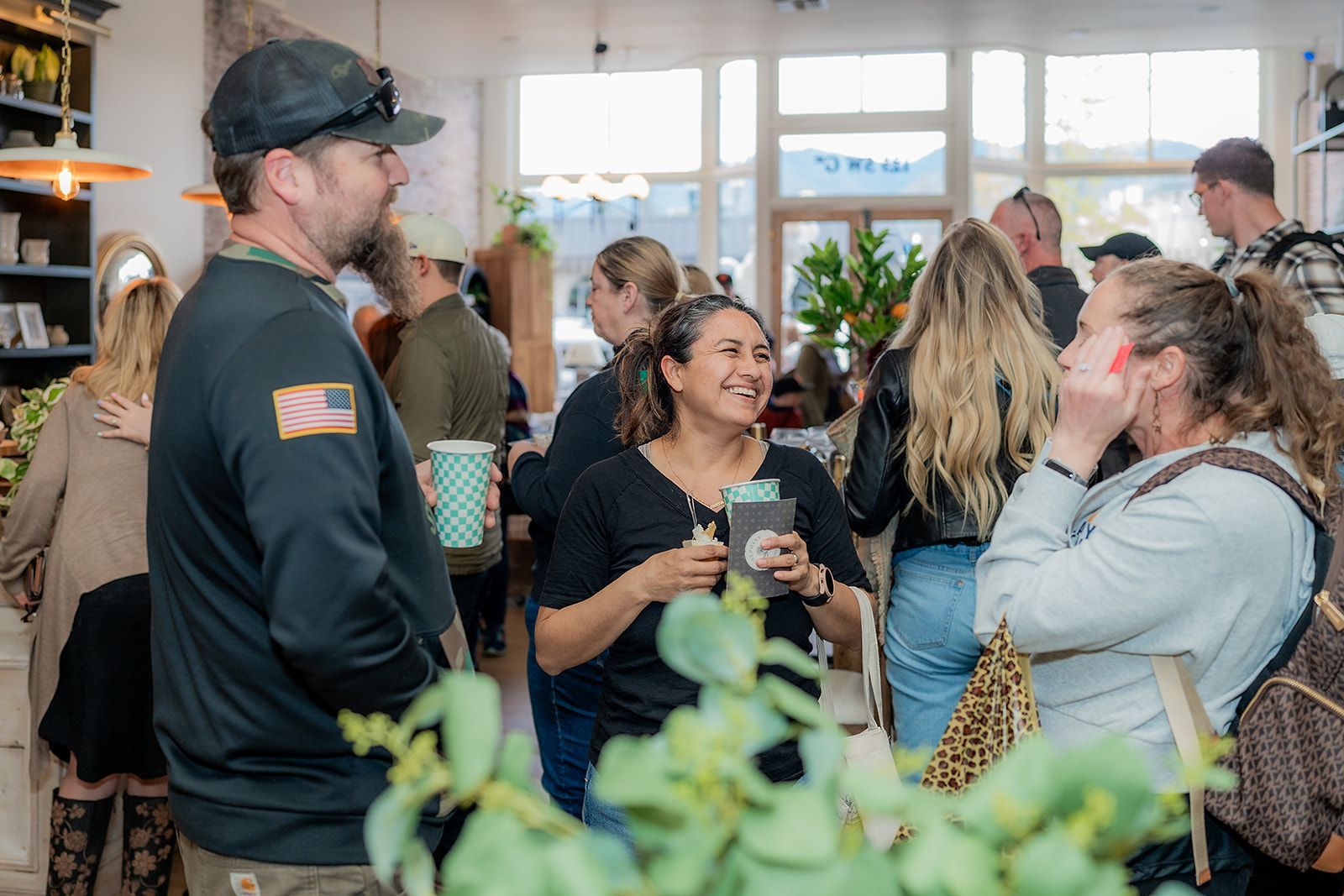 A group of people are standing in a room talking to each other.