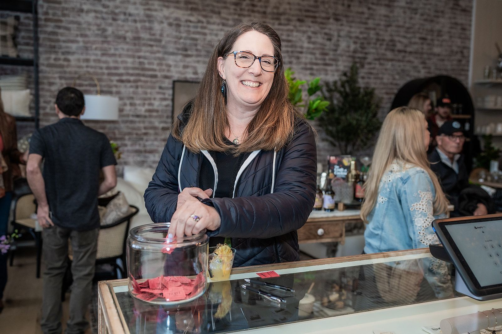 A woman is standing behind a counter in a store.