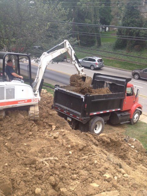 An excavator is loading dirt into a dump truck