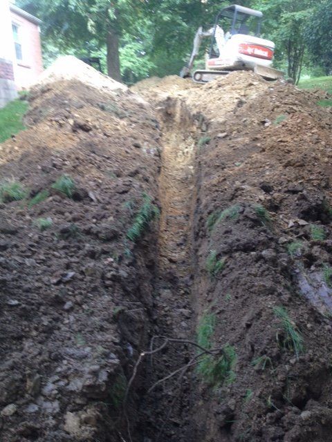 A bulldozer is digging a trench in the dirt.