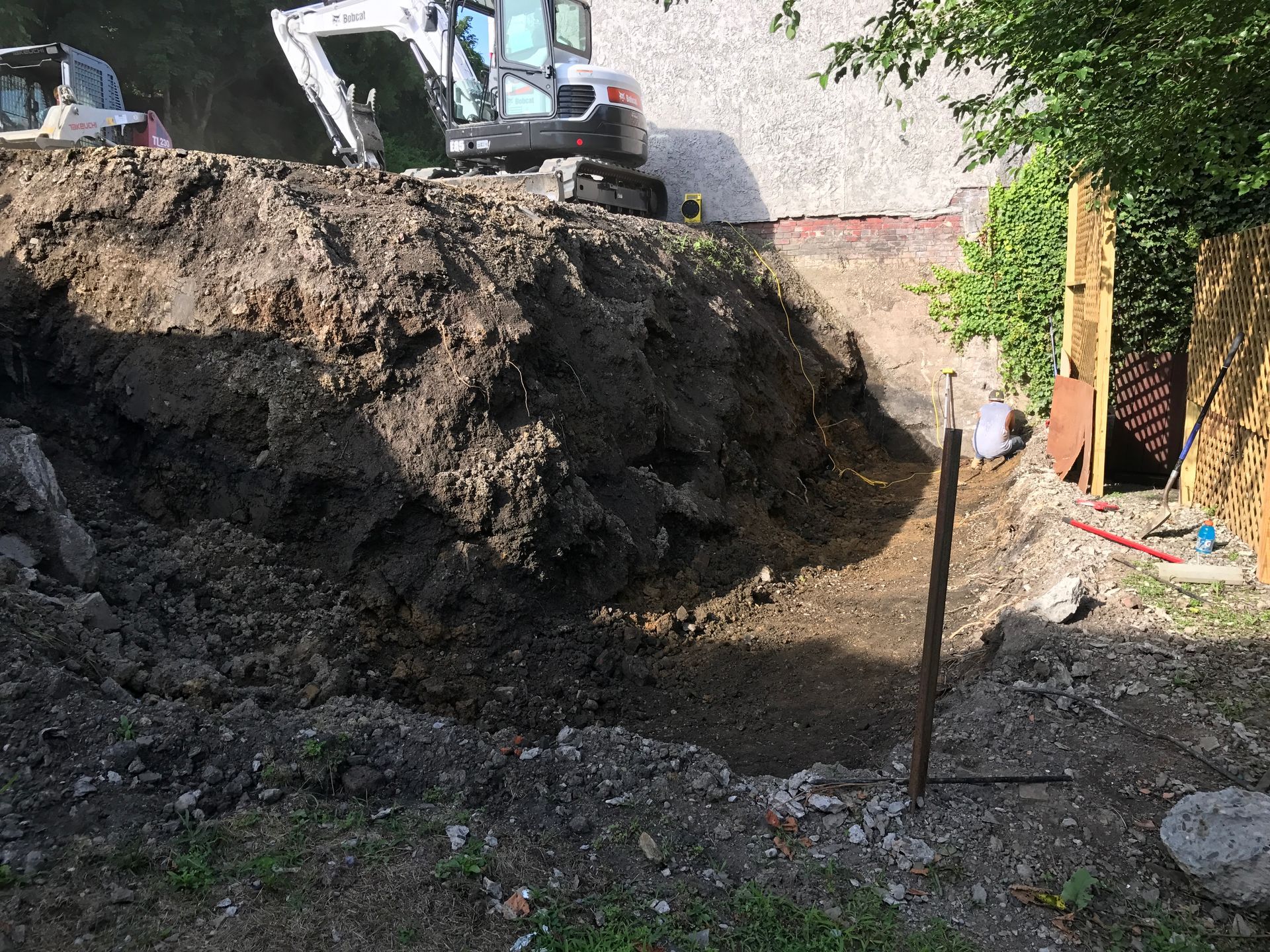 A large pile of dirt is sitting in front of a building.