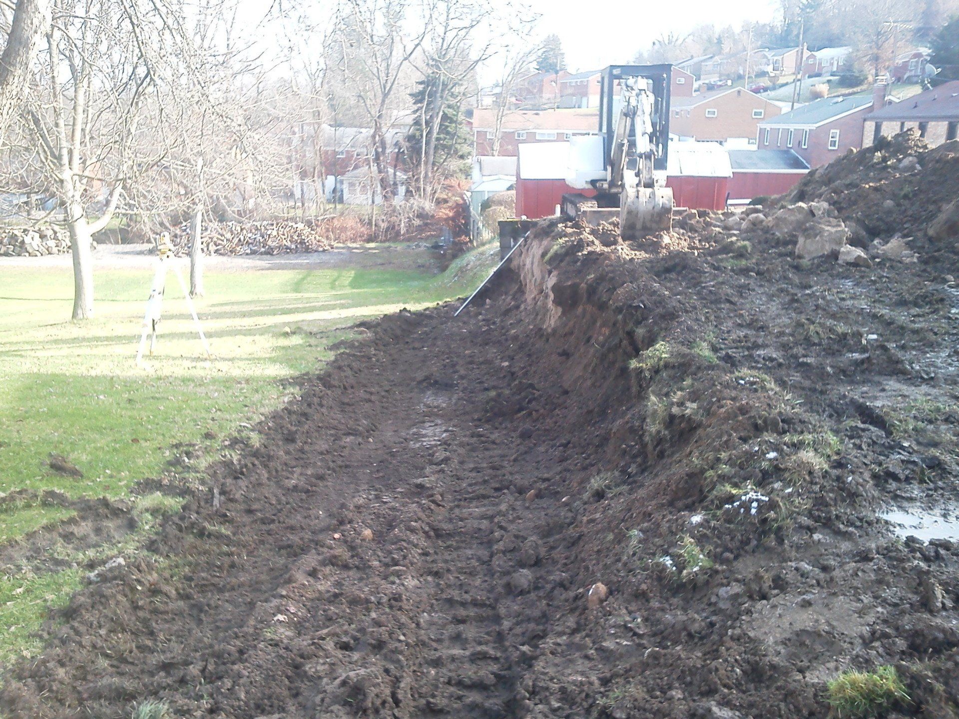 A forklift is digging a hole in the dirt in a park