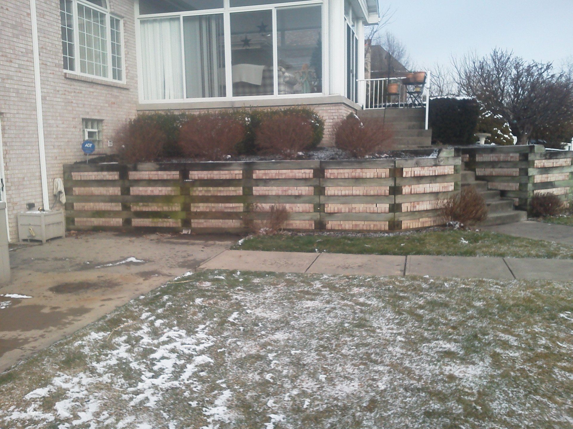 A brick house with a wooden fence in front of it