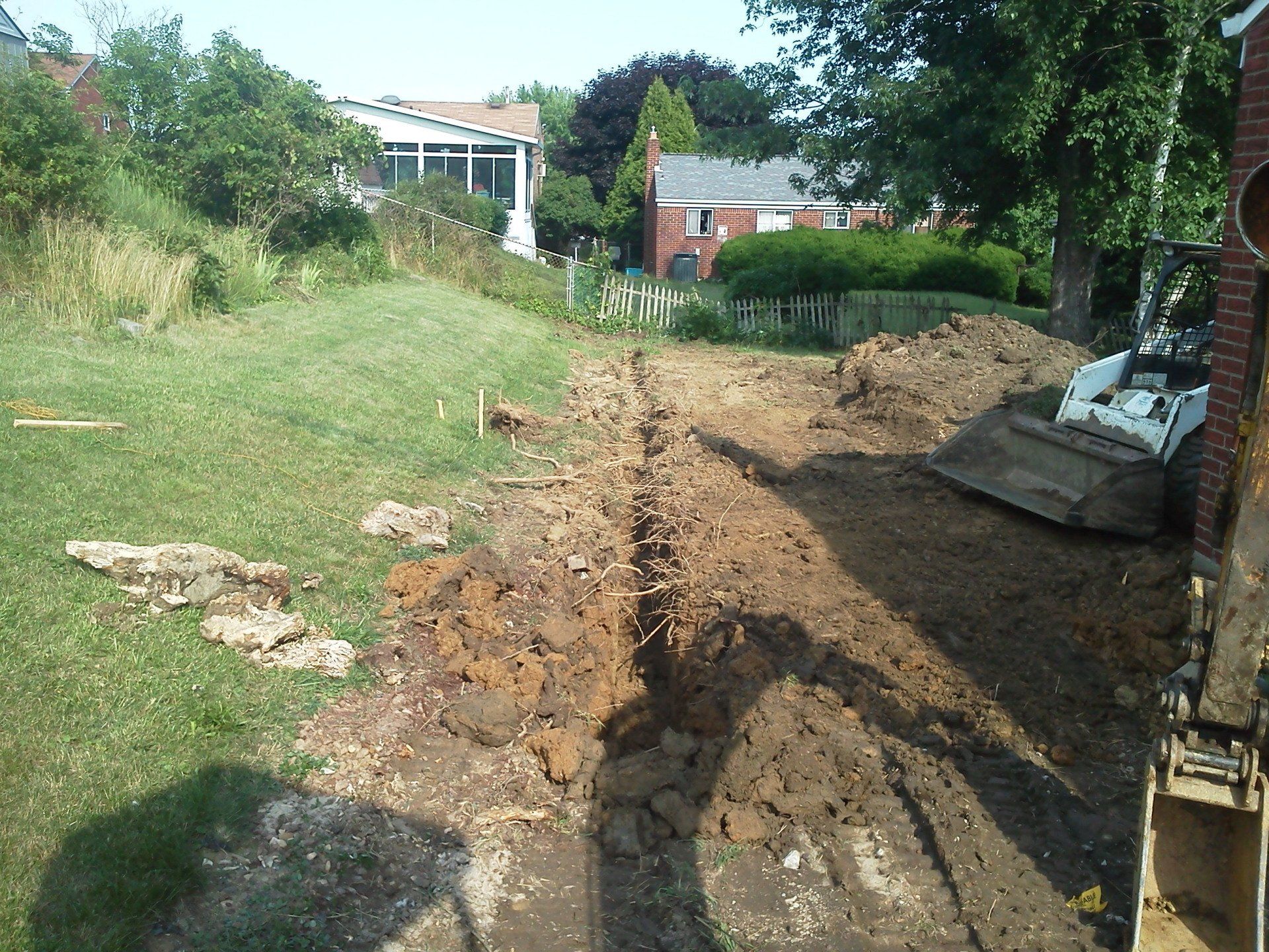 A bulldozer is digging a hole in a yard