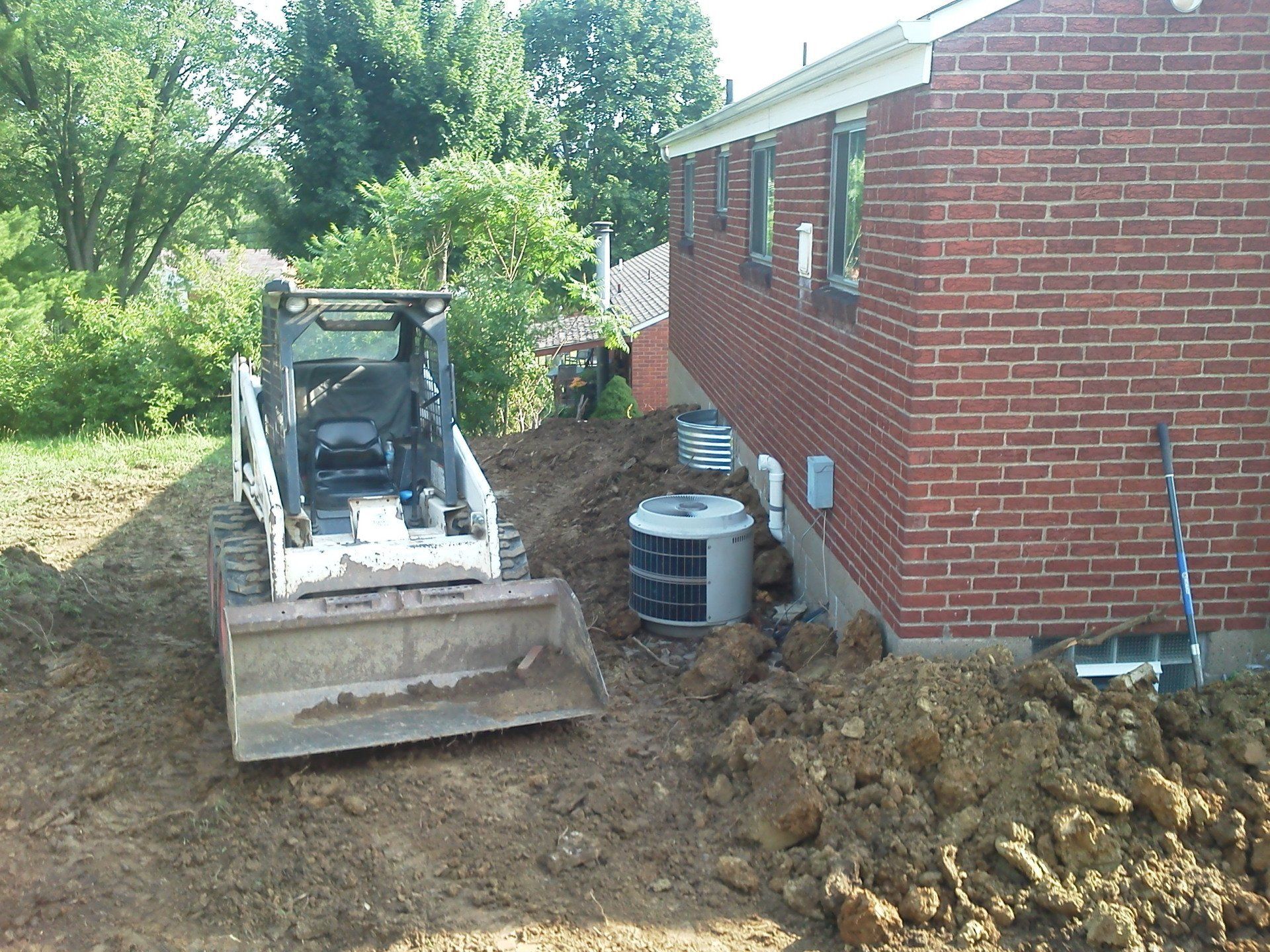 A bulldozer is parked in front of a brick building