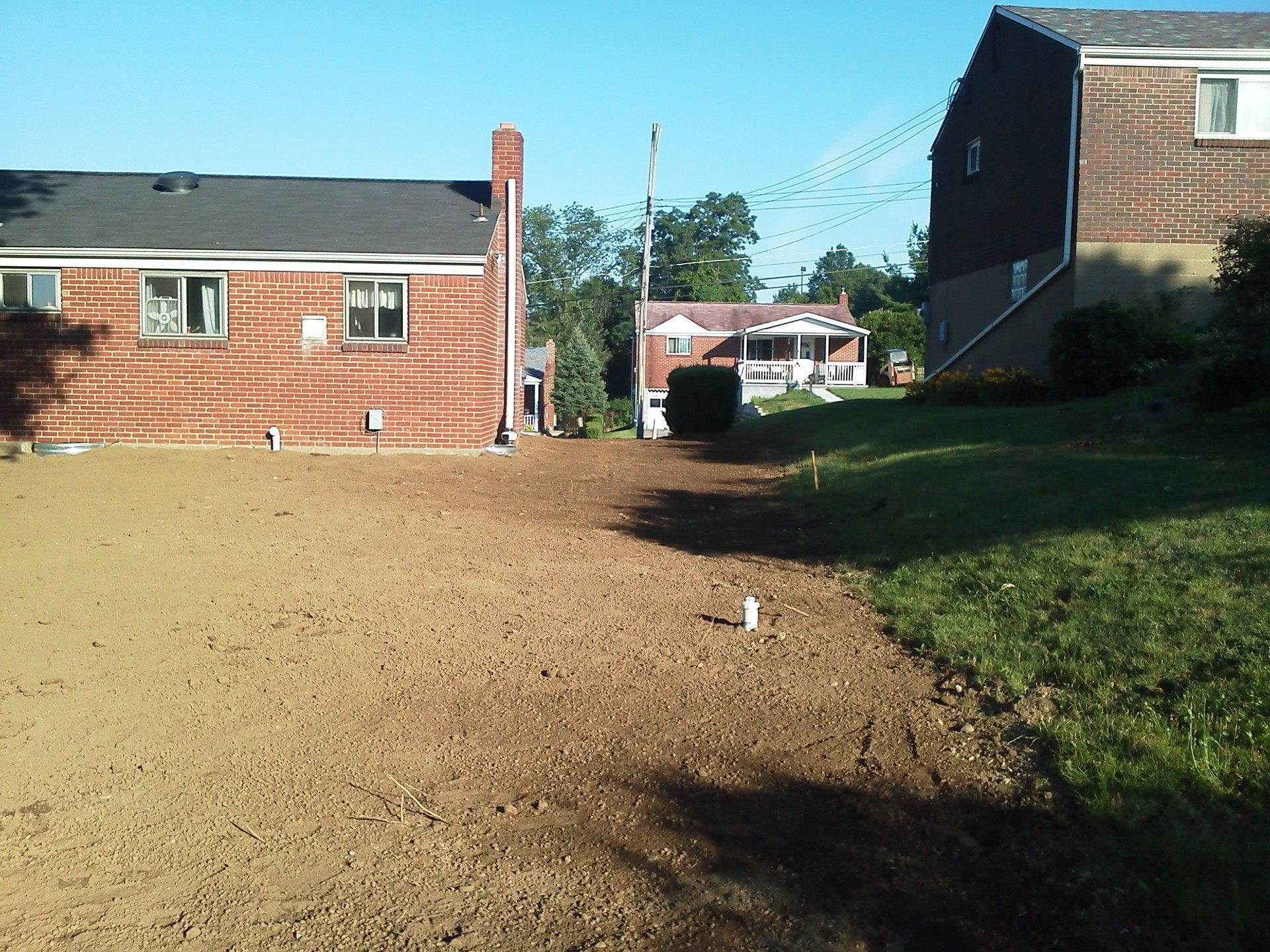 A dirt road leading to a brick house