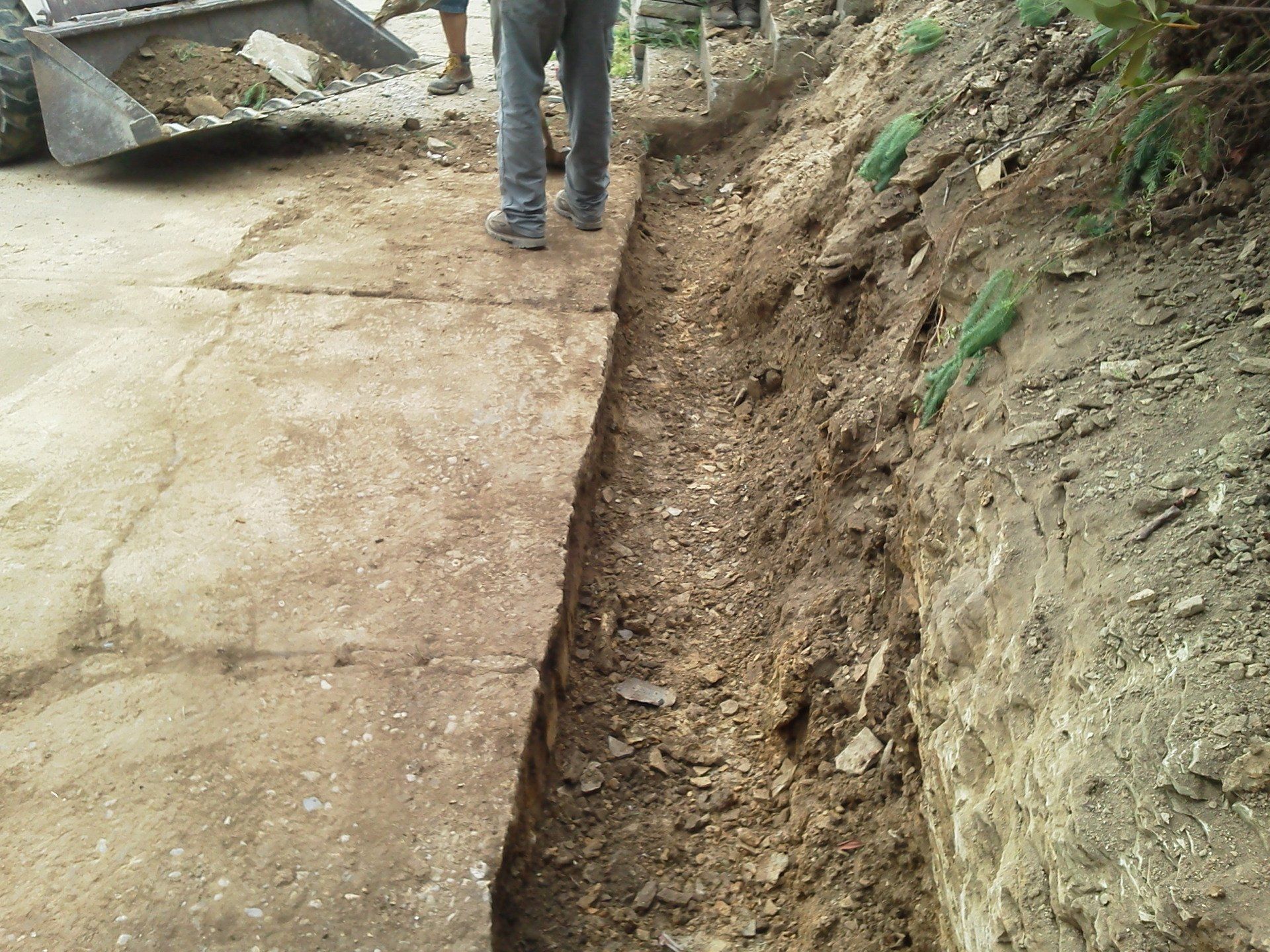 A man is digging a trench in the dirt