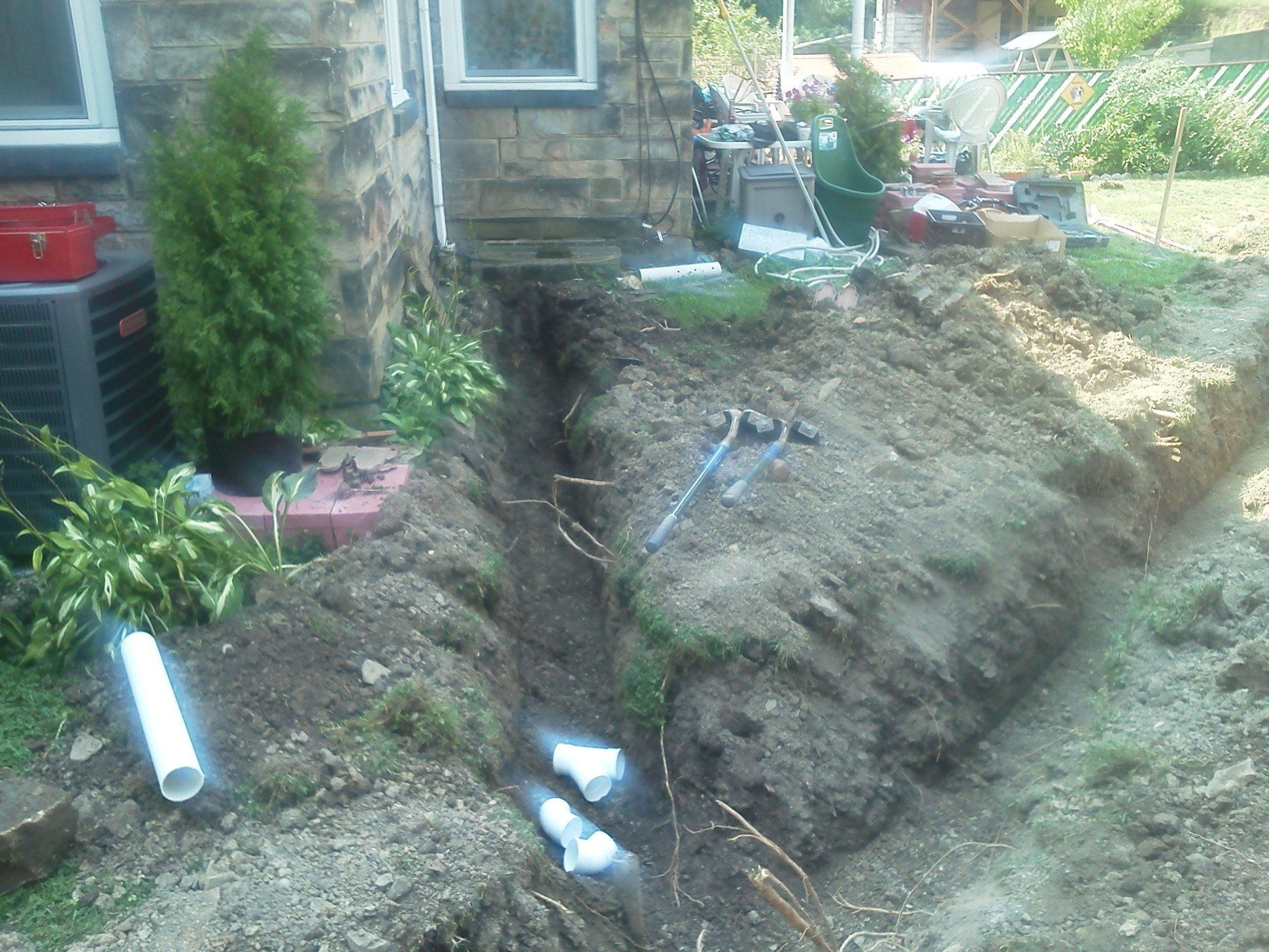 A large hole in the ground in front of a house