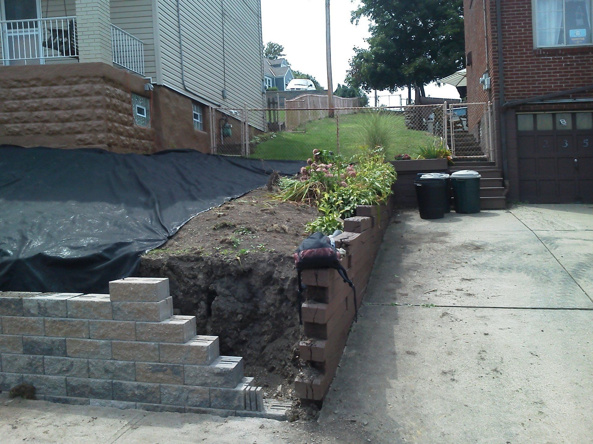 A brick wall is being built in front of a house