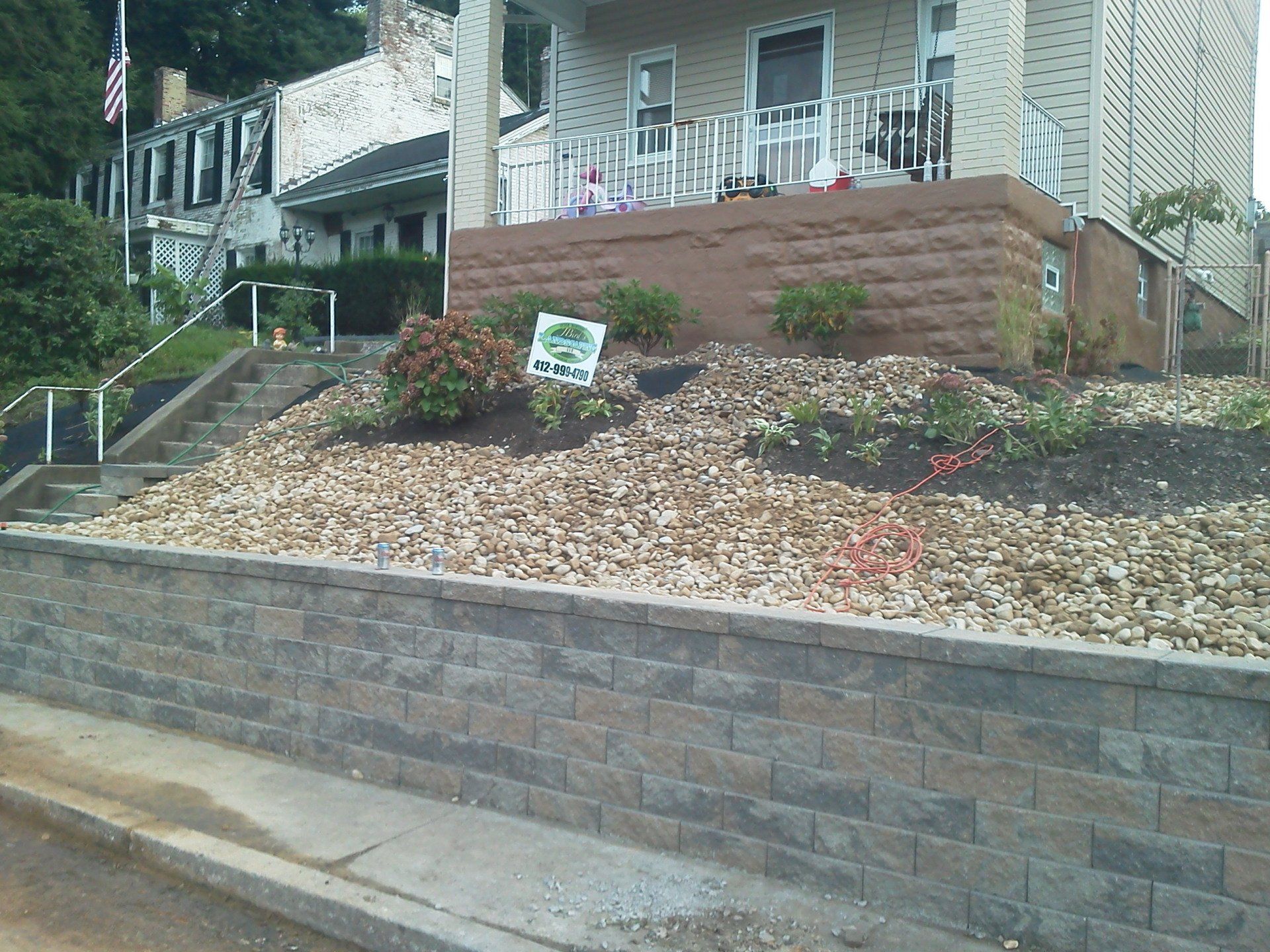 A brick wall surrounds a house with a sign that says ' i love you ' on it