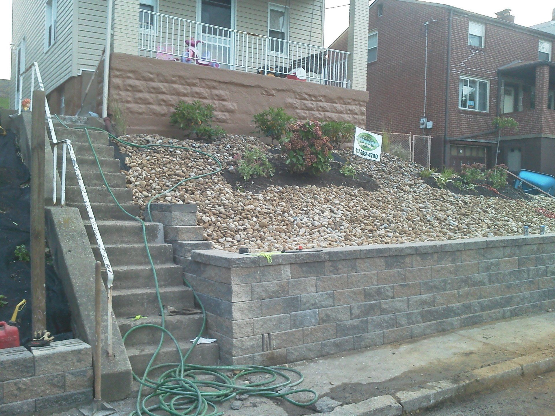 A hose is attached to a brick wall in front of a house