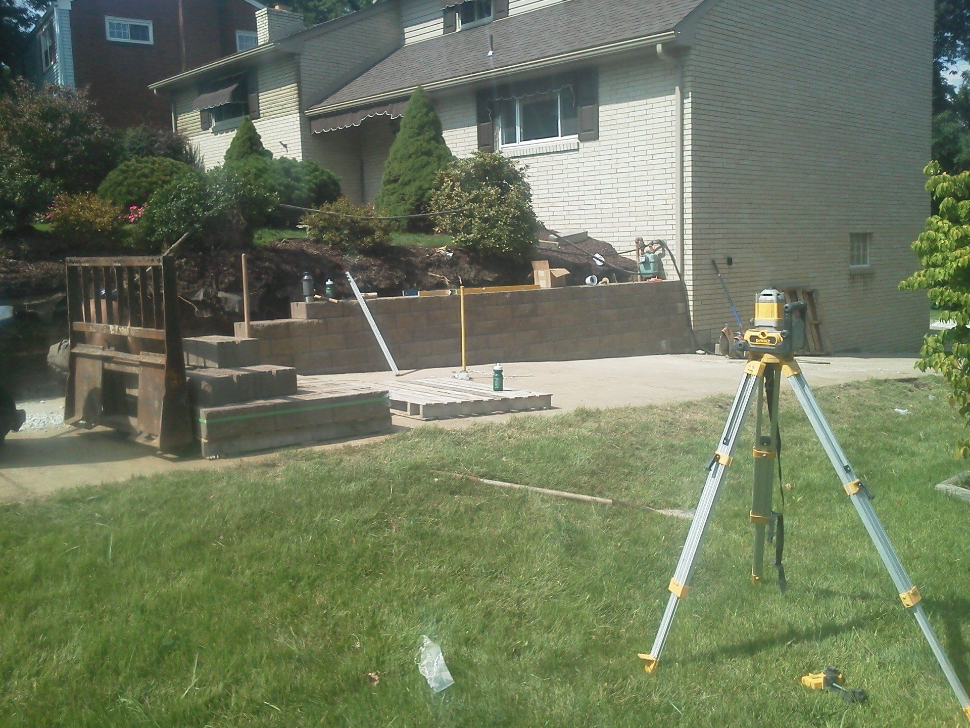 A tripod is in the grass in front of a house
