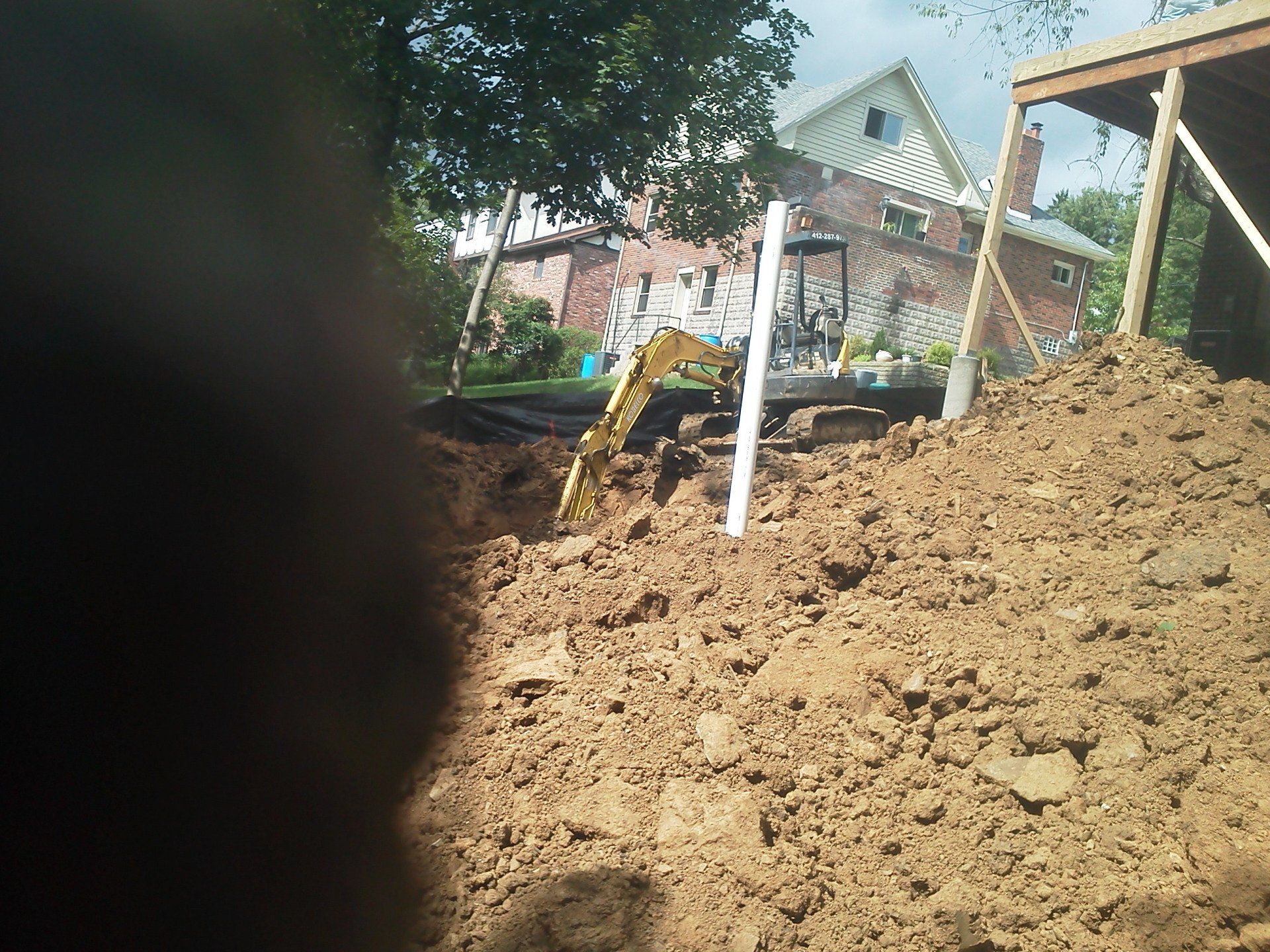 A large pile of dirt with a house in the background