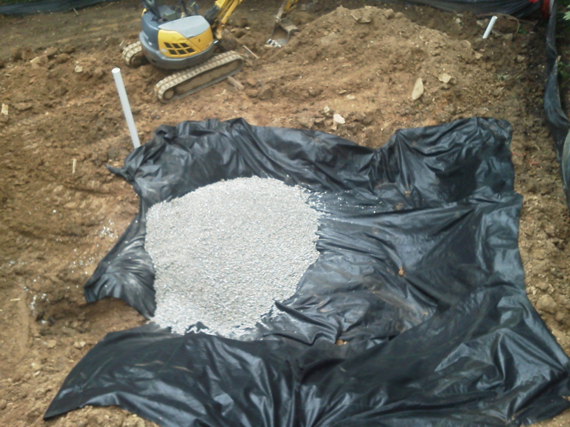 A pile of gravel is sitting on top of a black tarp