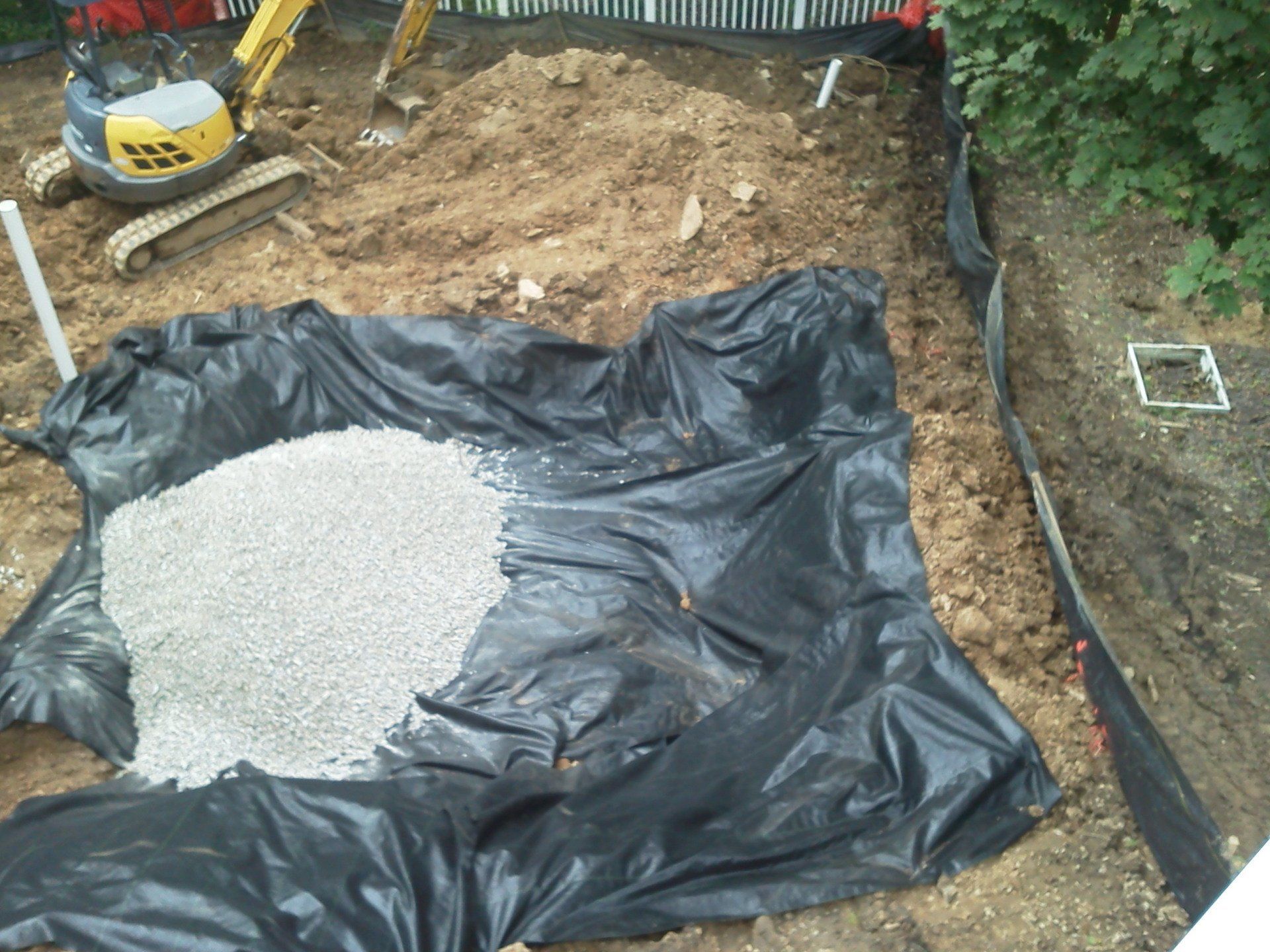 A pile of gravel is sitting on top of a black tarp