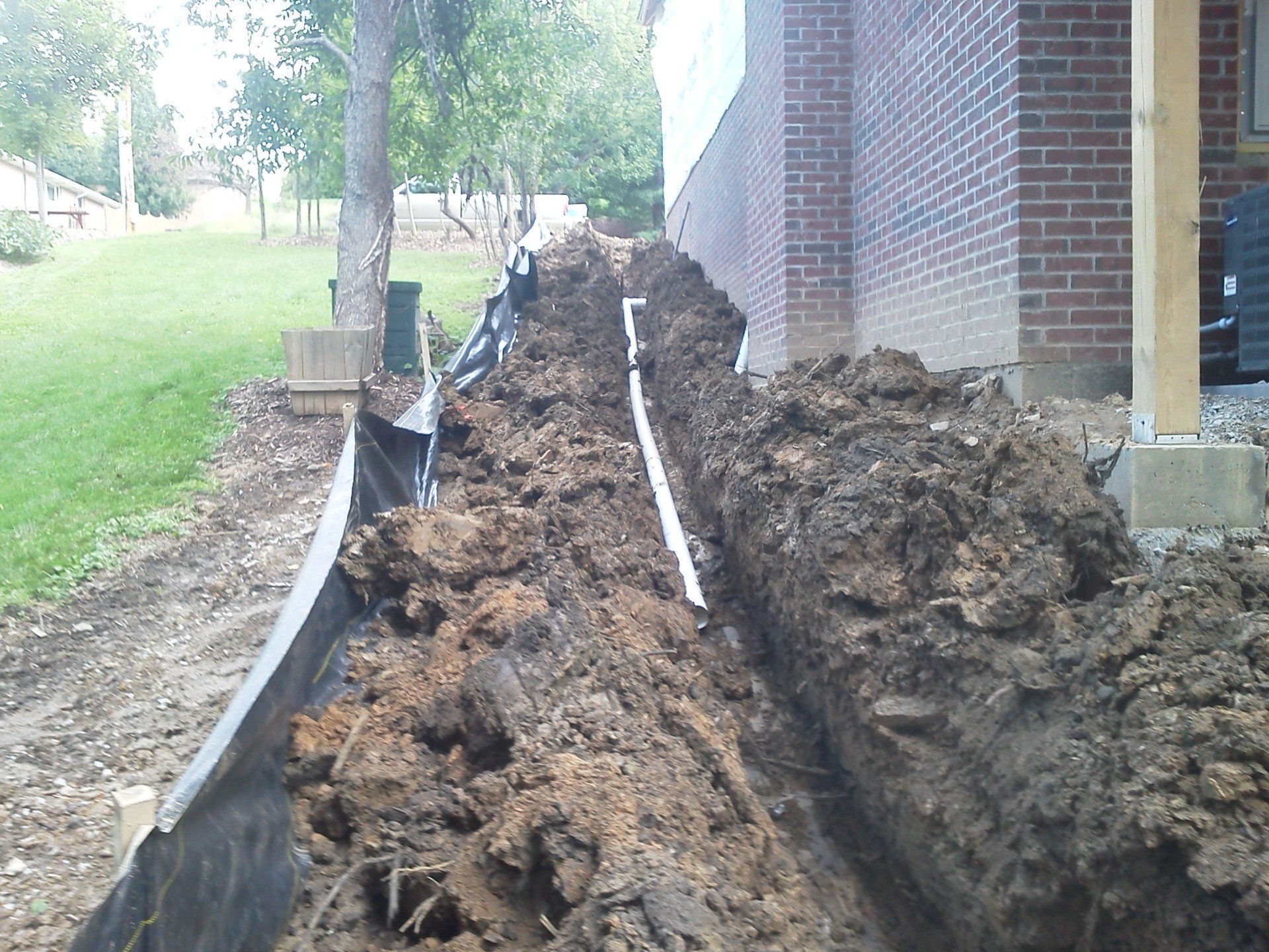 A large pile of dirt in front of a brick building