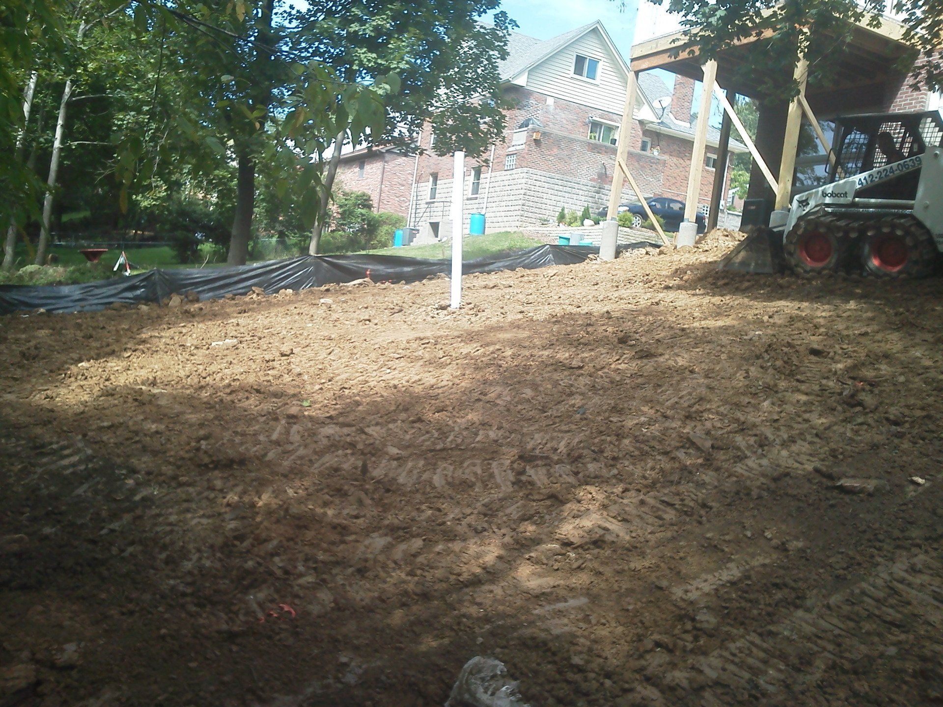 A large pile of dirt with a house in the background