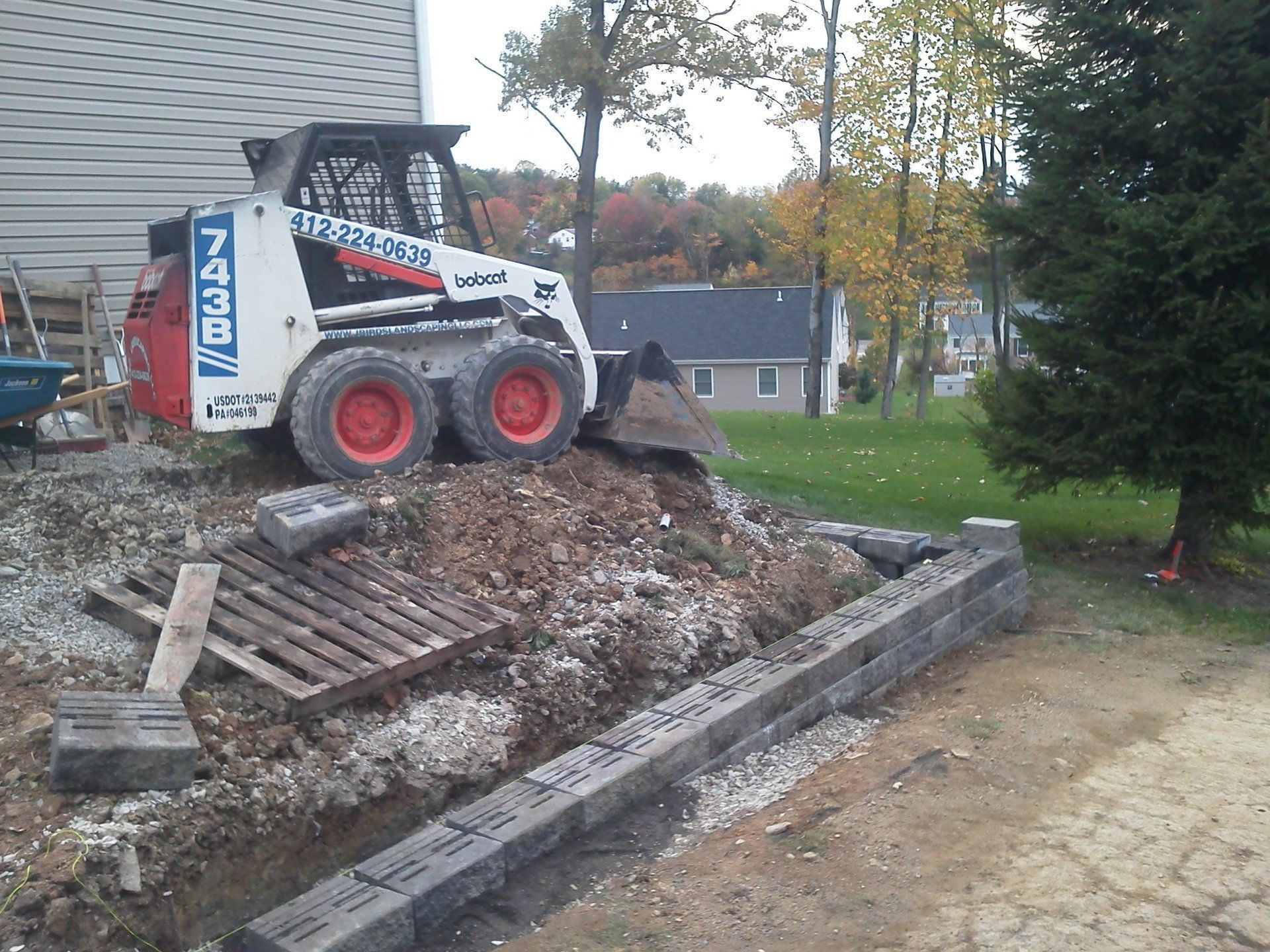 A bobcat skid steer is sitting on top of a pile of dirt